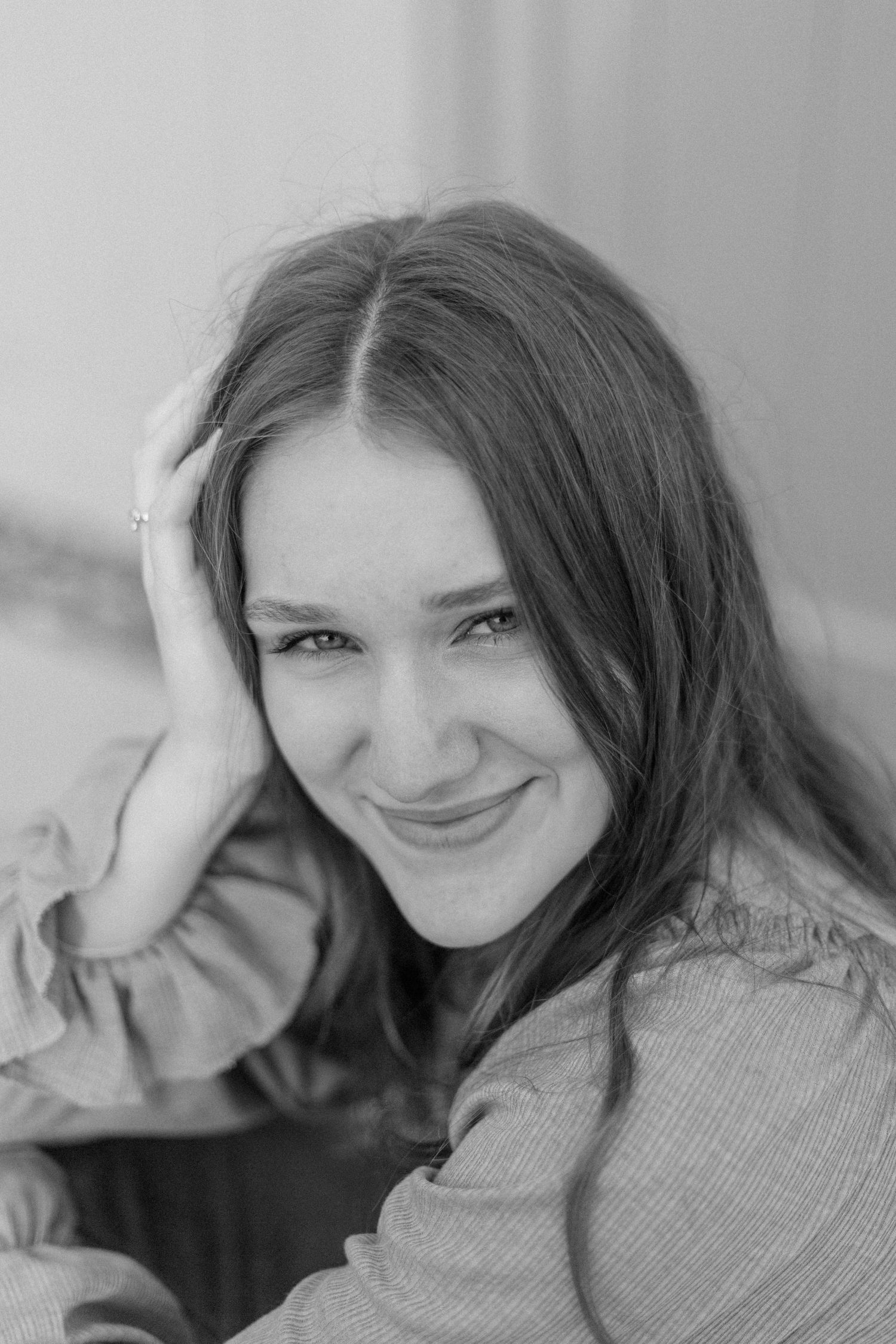 black and white photo of a high school senior girl smiling at the camera for senior photos