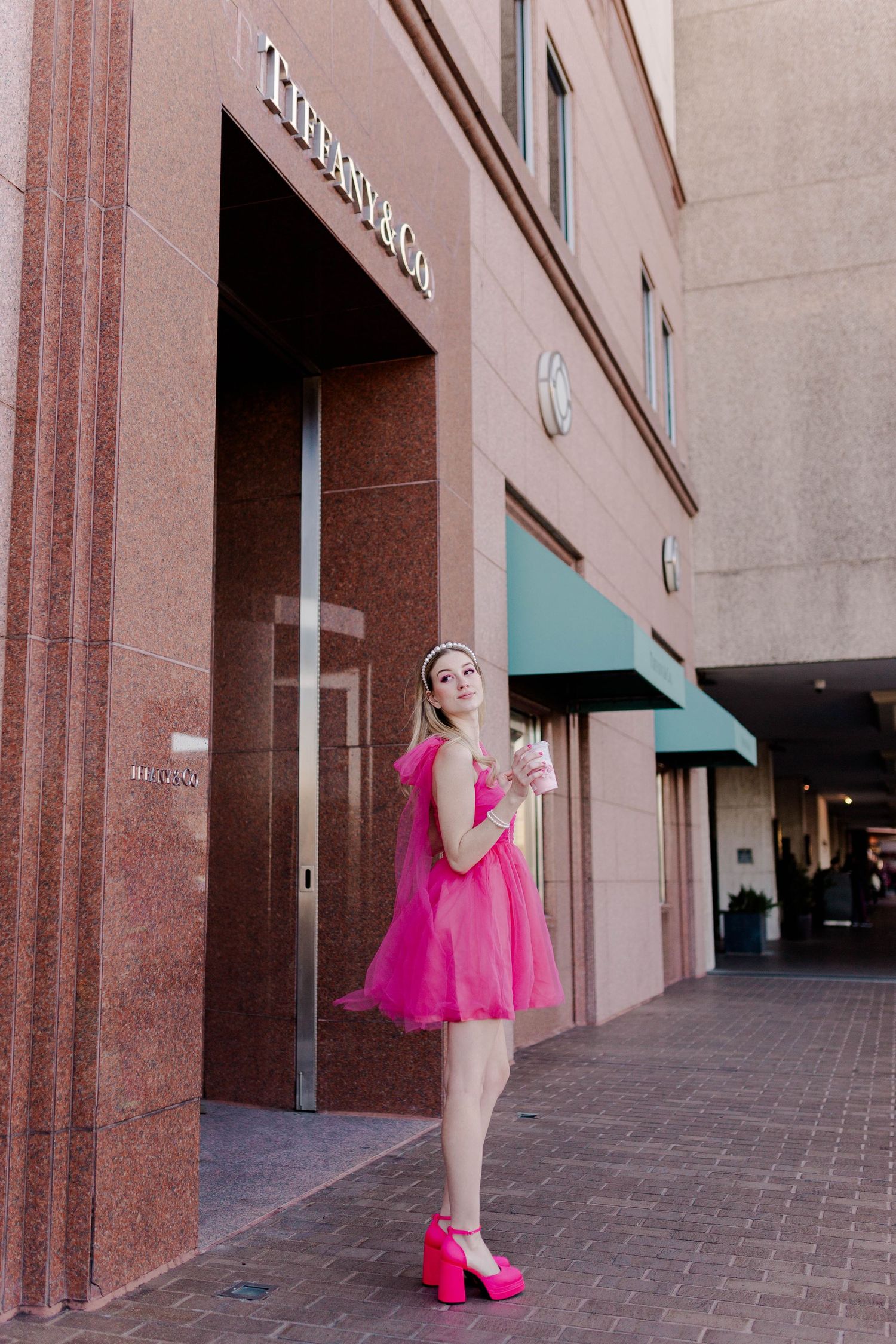 blonde model in hot pink dress and heels in front of Tiffany & Co at the Galleria in Houston, Texas for a barbie themed photoshoot