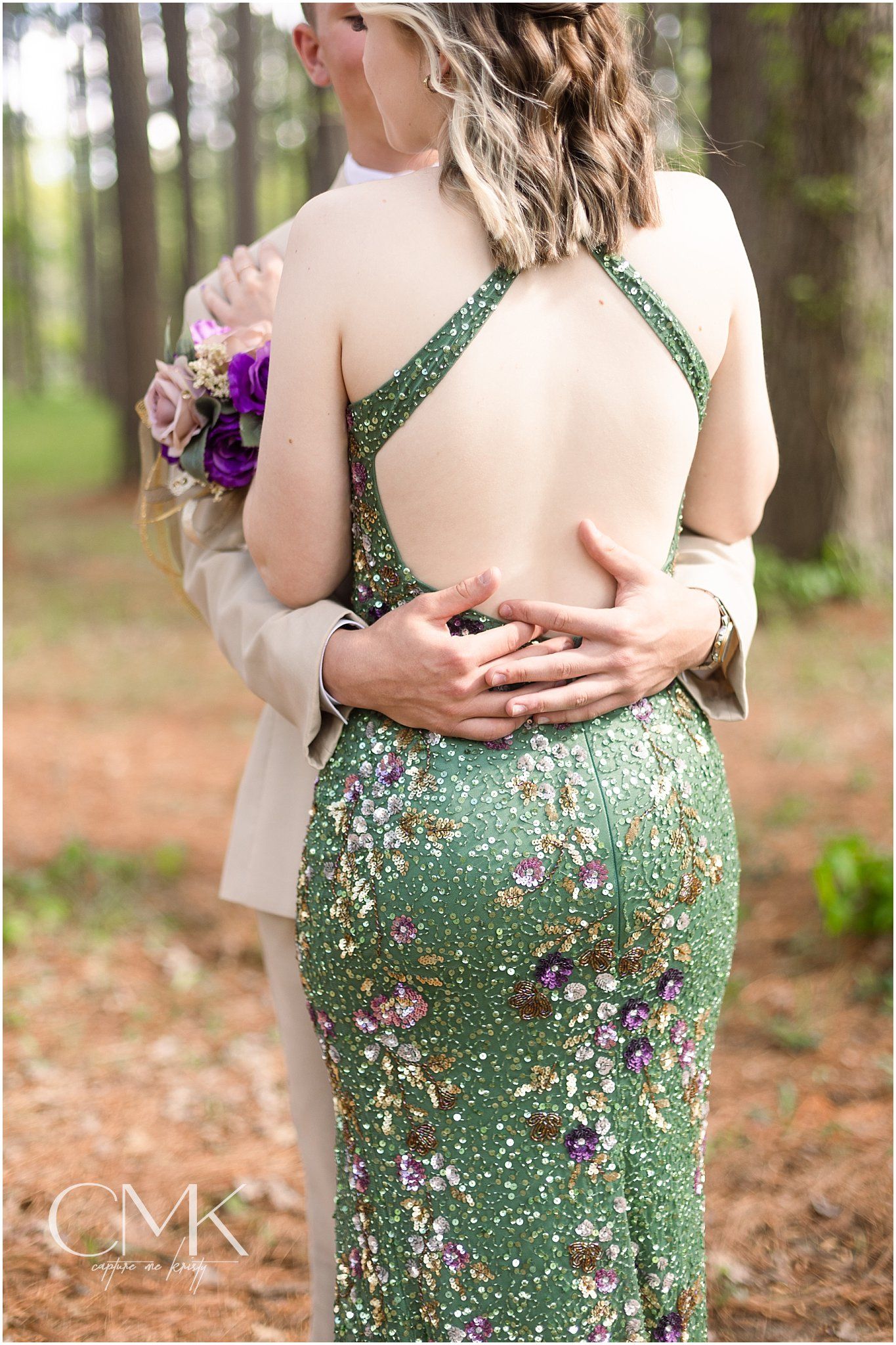 Back detail of a green sequined dress with cross-back straps during an outdoor formal photoshoot.