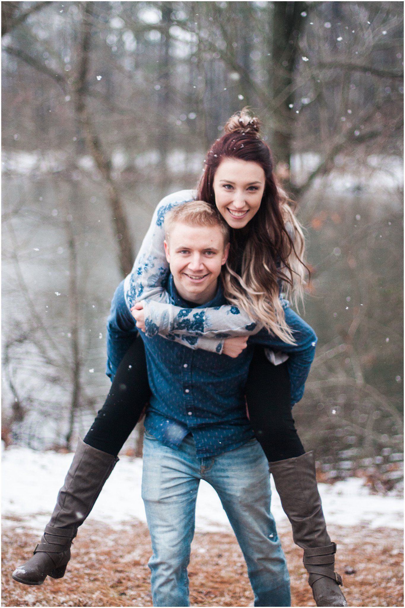 Happy couple sharing playful piggyback ride moment in snowy winter forest.