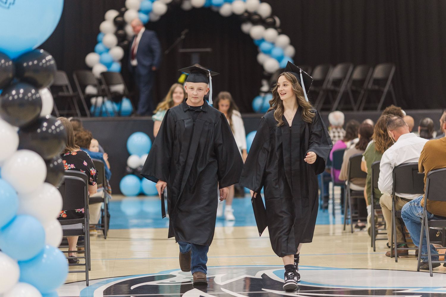 Graduation ceremony setup with blue and white balloon decorations along the walkway.
