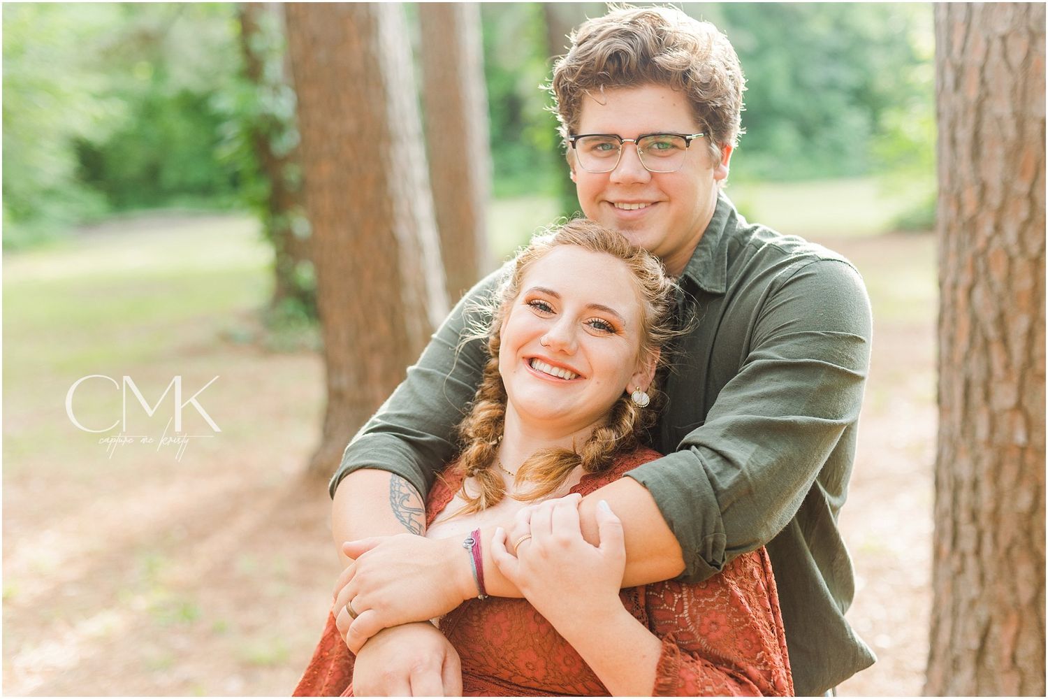 Sweet candid moment captured between couple during forest maternity session.