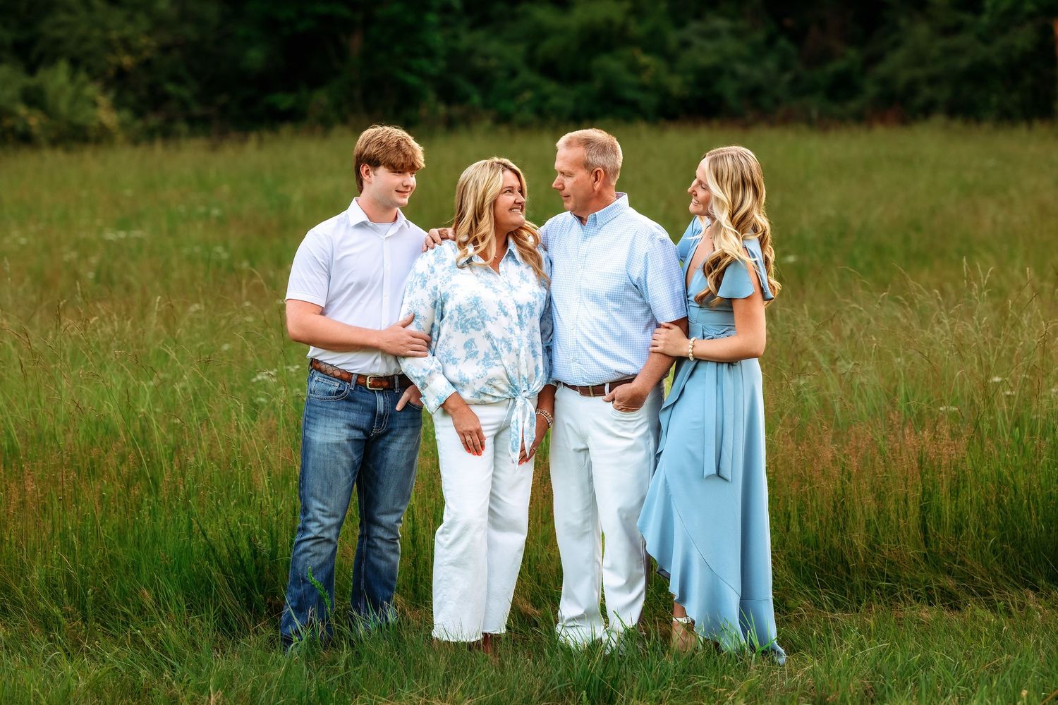 Extended family portrait session in an open field during golden hour.