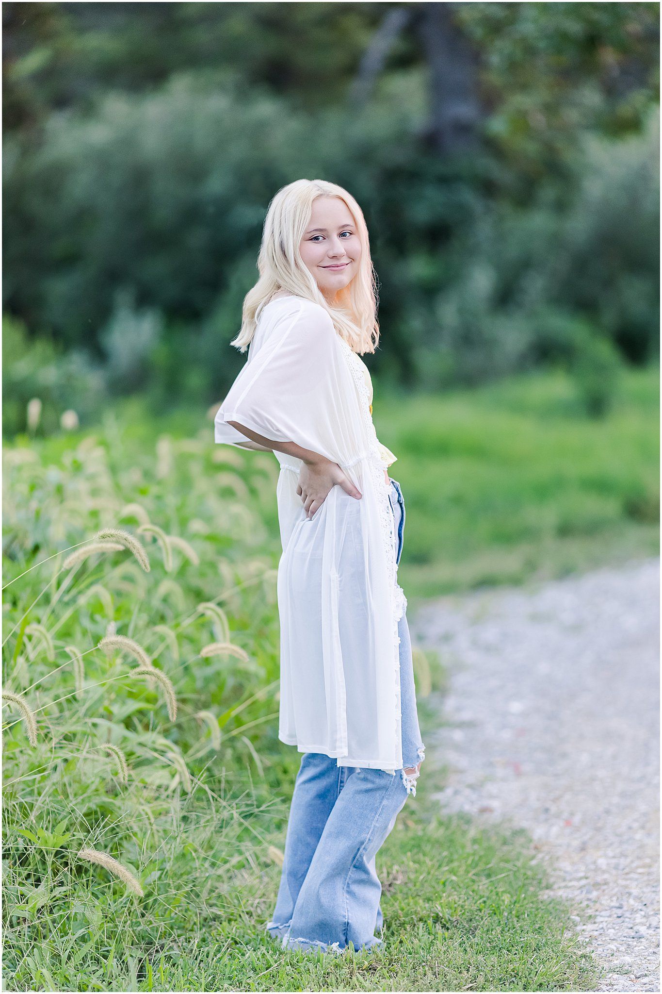 senior girl with hands on hips looking back at camera