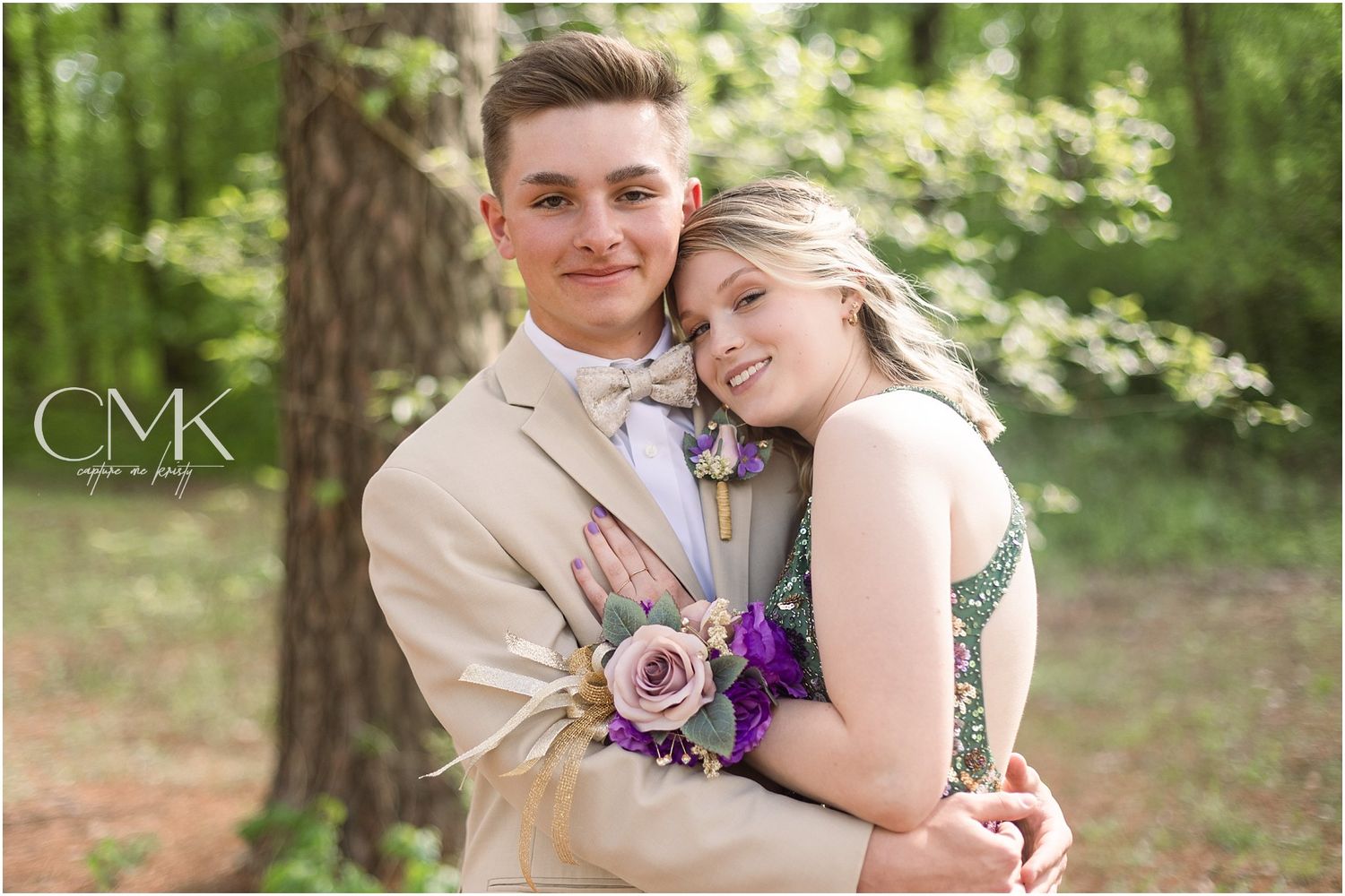 Romantic forest portrait of a couple at prom with tan suit and green sparkly dress.