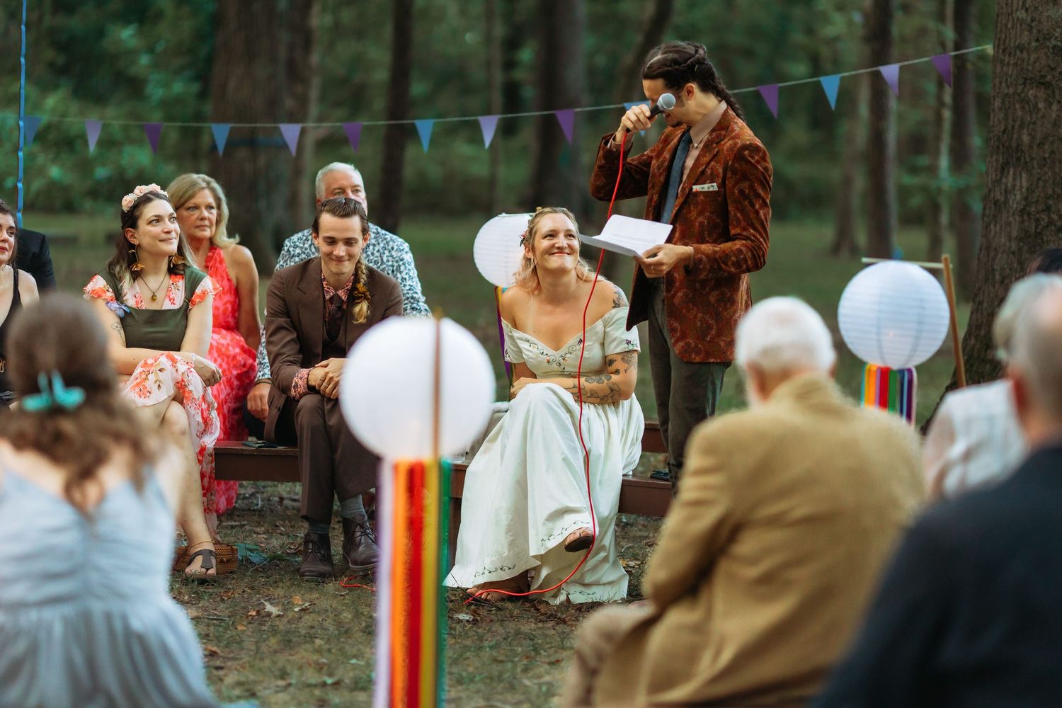 An intimate outdoor wedding ceremony with vintage-inspired decor and white lanterns.
