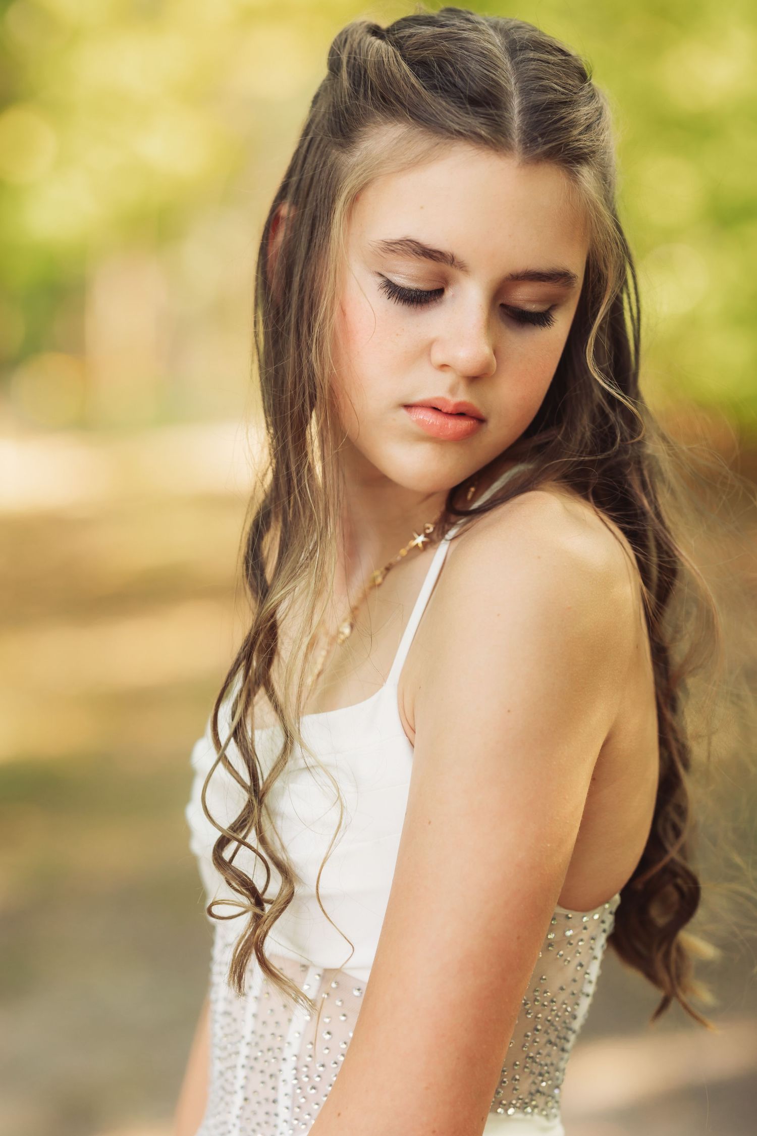 Close up details of a white lace dress with delicate embellishments in natural lighting.
