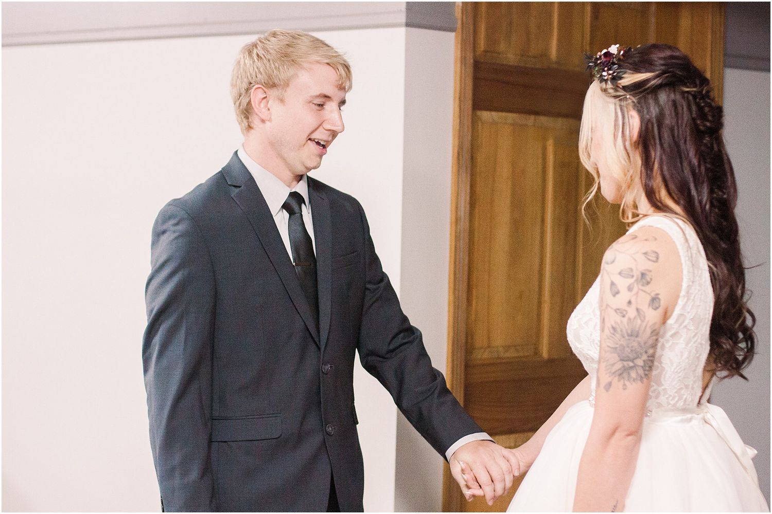 A touching first look moment between a couple on their wedding day in an indoor venue.