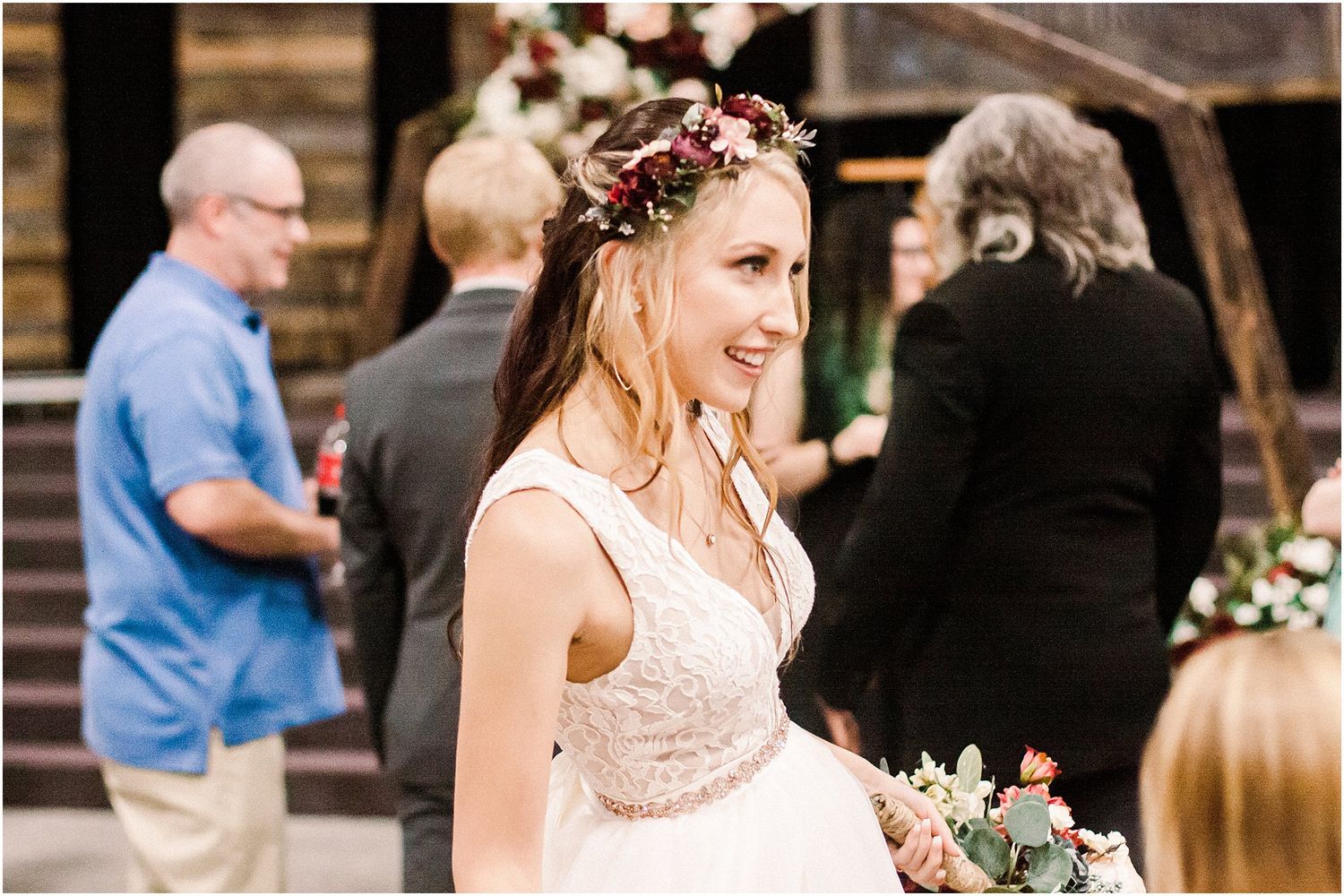 Outdoor wedding celebration with floral decor and rustic wooden steps in background.