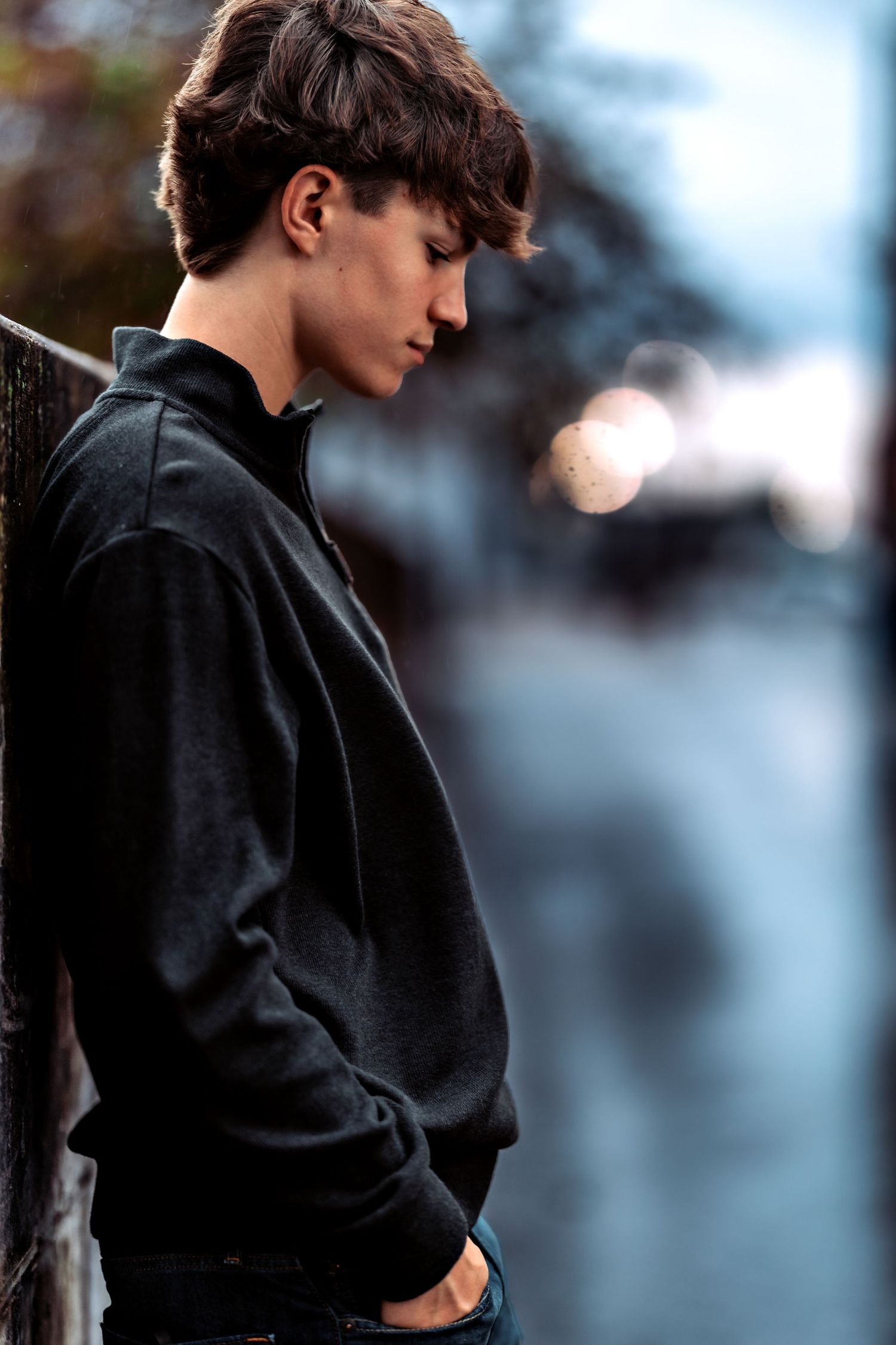 Silhouette of someone in a black coat against a blurred urban background.