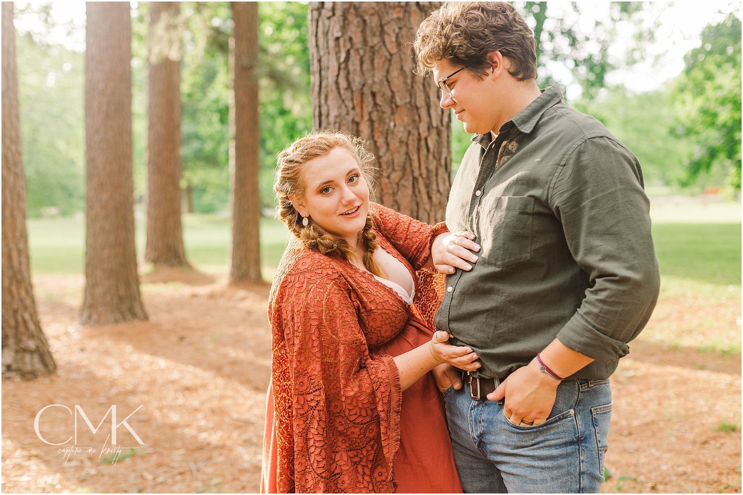 Romantic couple's maternity photo shoot in a pine forest.