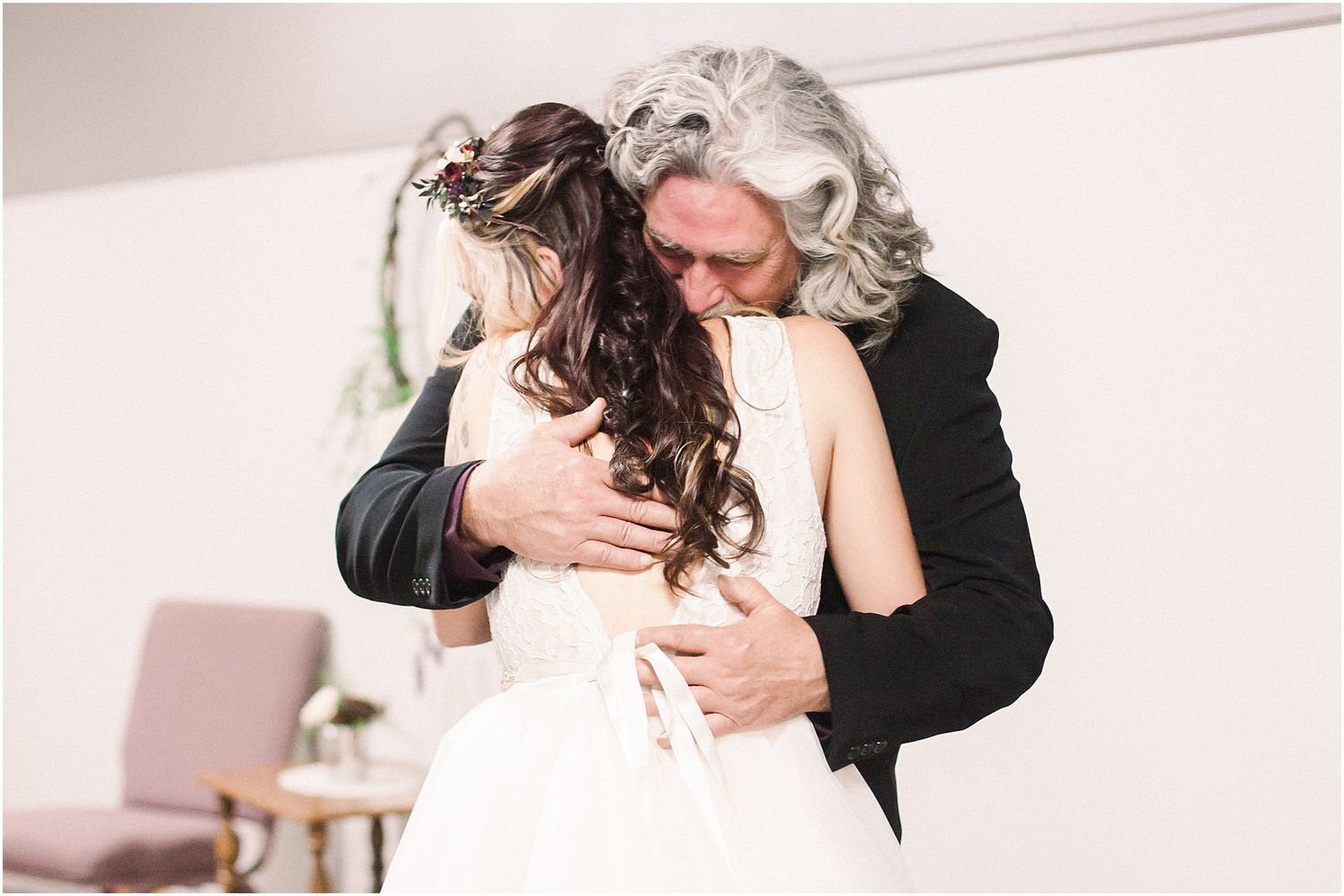 An emotional embrace captured during a wedding first look moment indoors.
