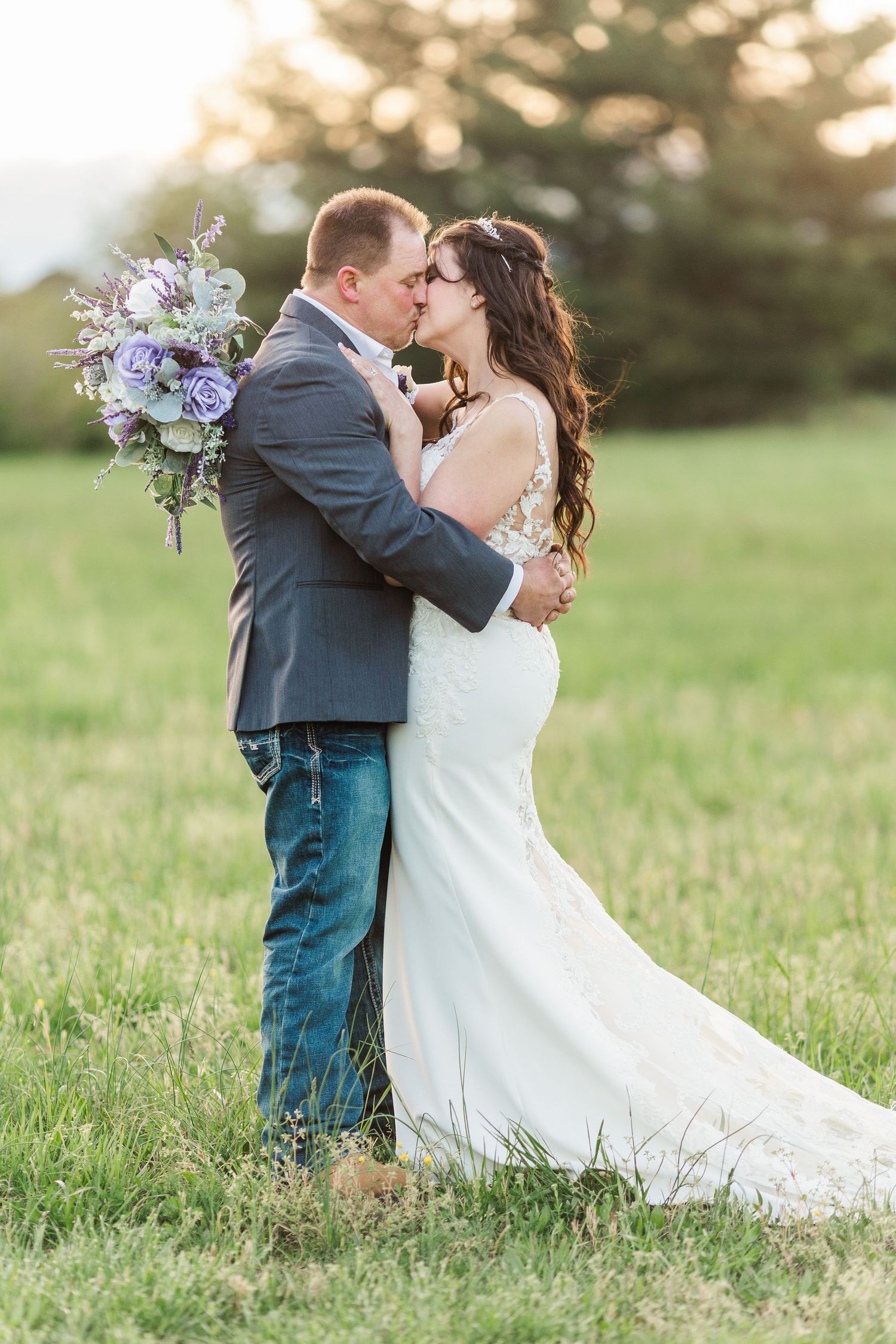 Romantic couple's portraits in sunlit field with purple floral bouquet.