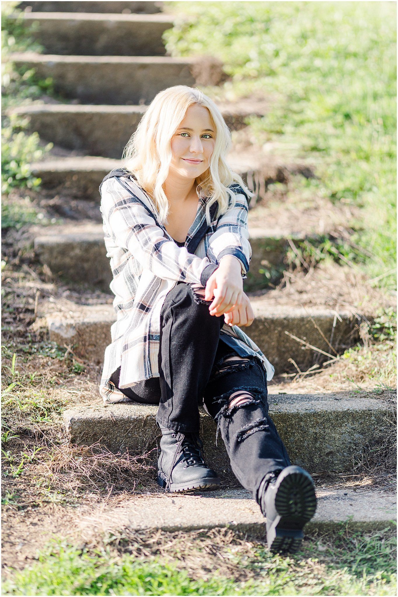 Senior girl sitting on stone steps going down grassy hill