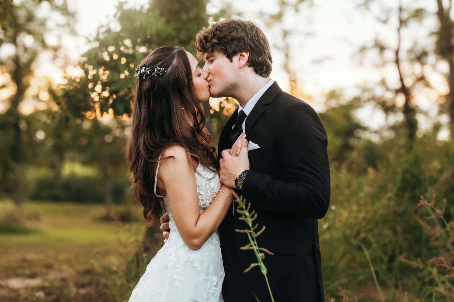 A romantic wedding portrait of a couple sharing an intimate moment in a golden sunset garden setting.
