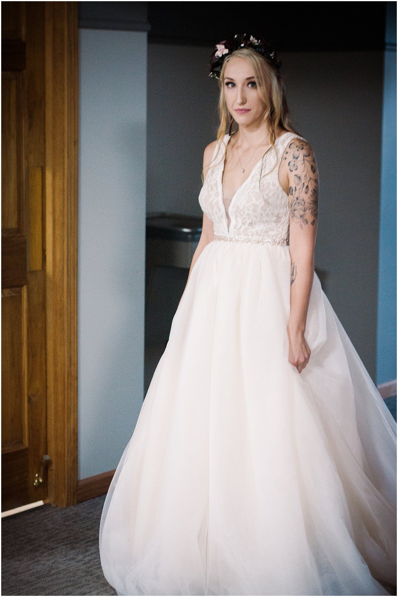 Full-length view of romantic tulle wedding gown with lace bodice and plunging neckline.