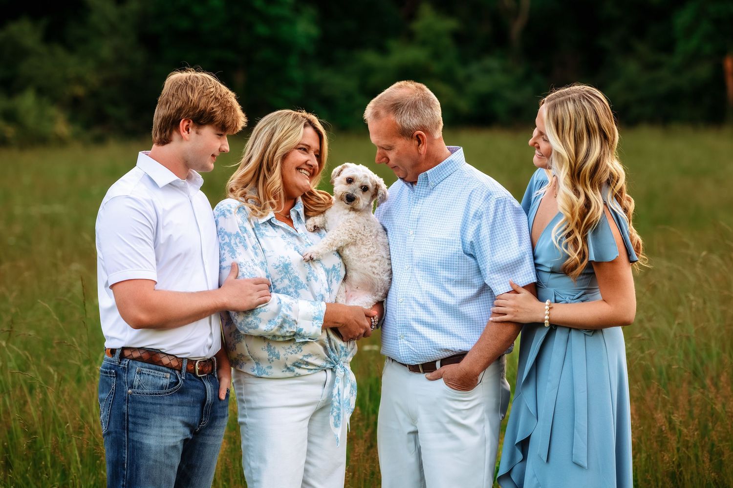 Family gathering photographed in a natural meadow setting at dusk.