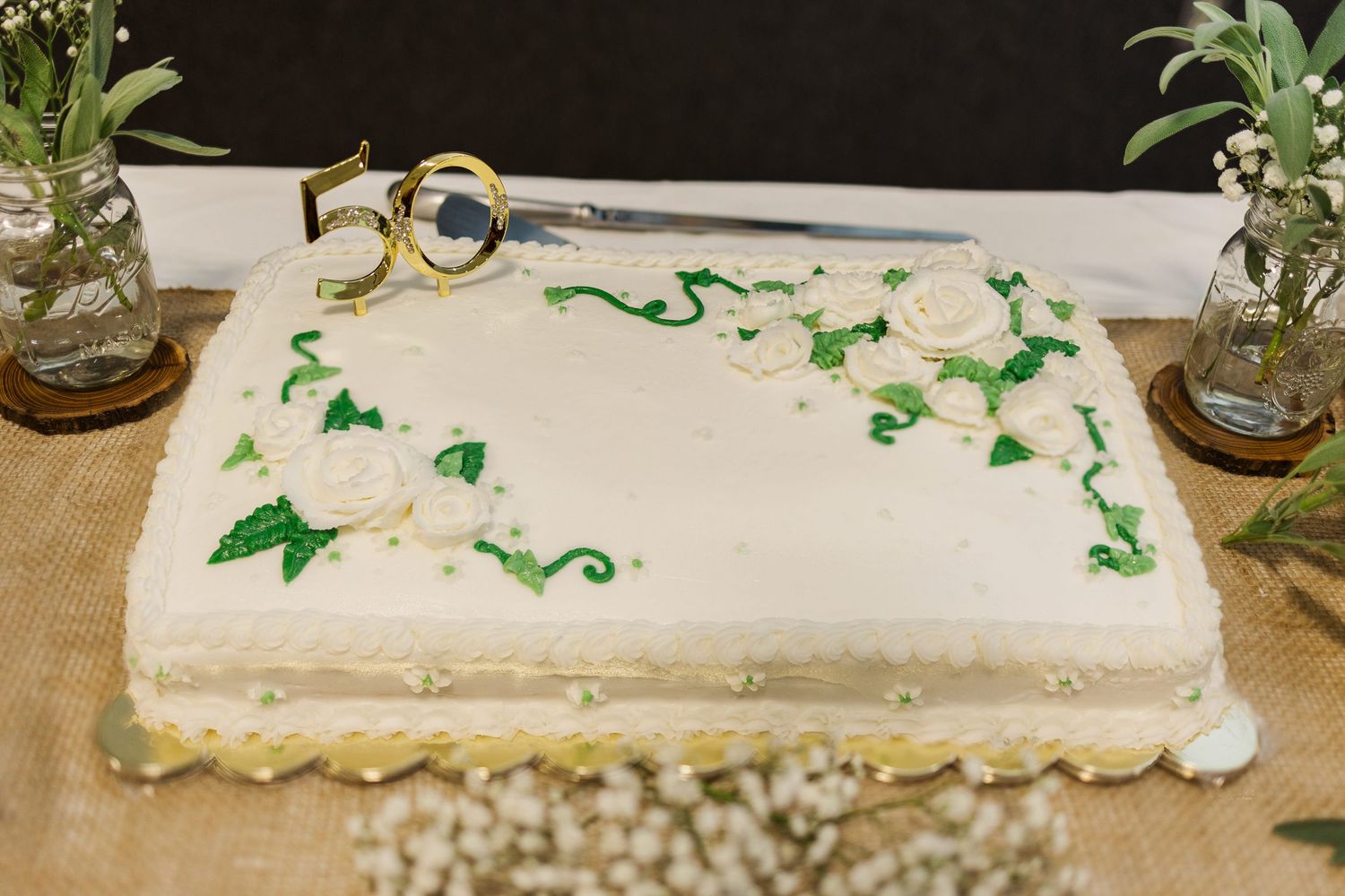 White table decorations with green accents arranged for a formal event.