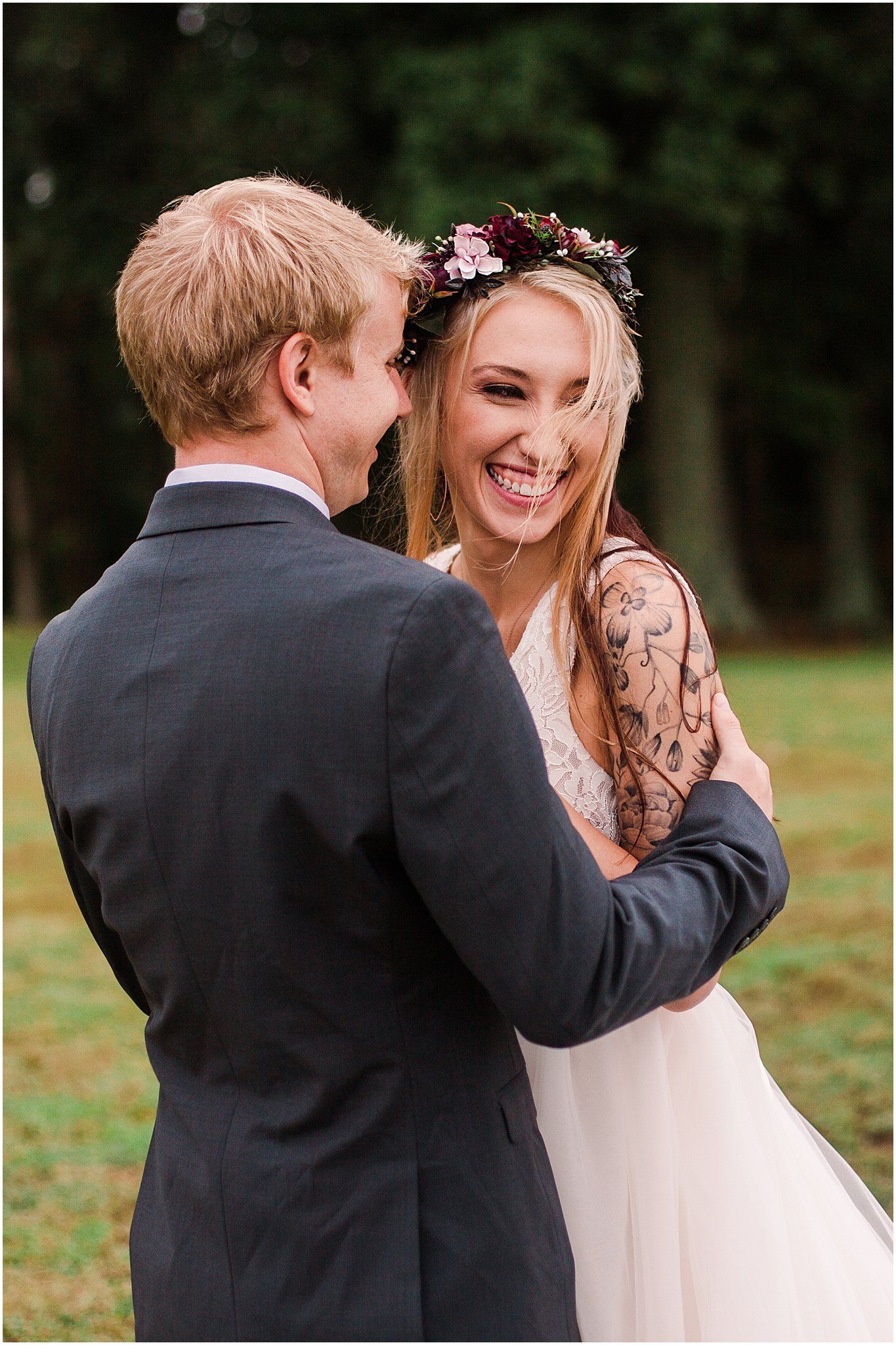 Joyful wedding couple sharing a laugh while embracing in a garden setting.