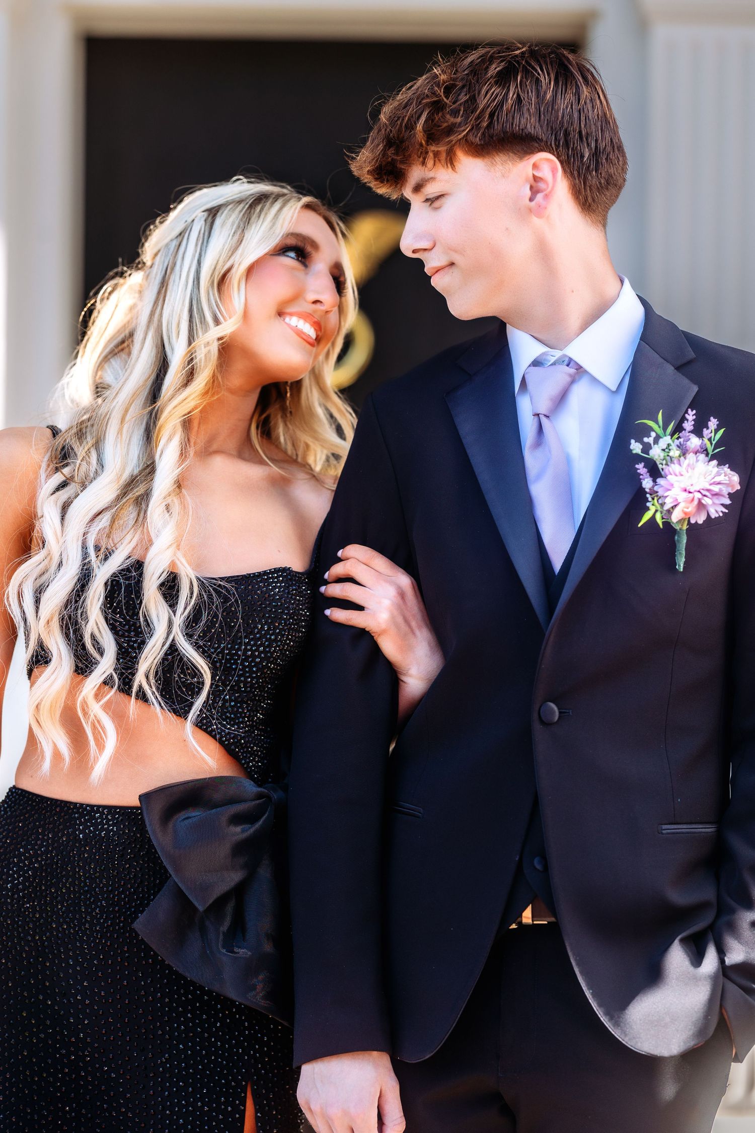 A couple in formal attire share intimate moments in a series of romantic black and white portraits.