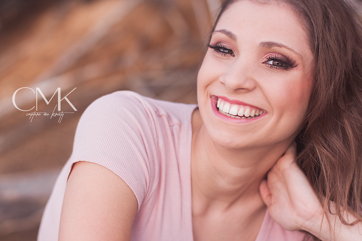 Natural light close-up portrait with joyful expression and pink top.