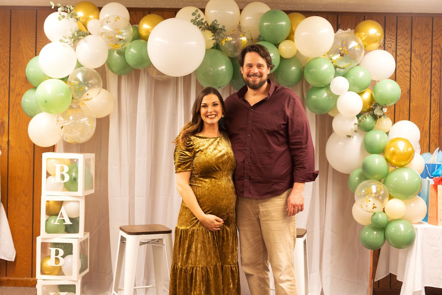 Festive party venue decorated with white and green balloon garlands and lanterns for a special celebration.