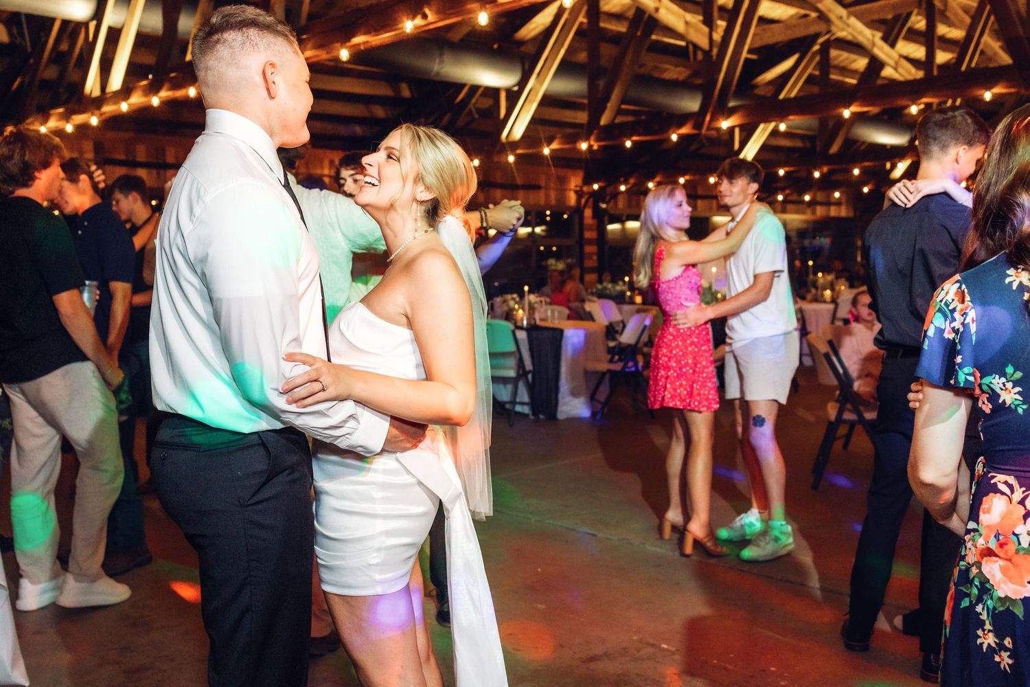 Wedding guests enjoying themselves on the dance floor during an evening reception.