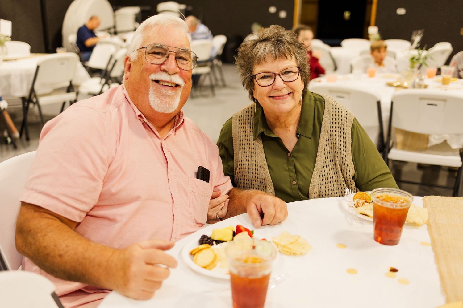 Guests enjoying a casual dining event with tables set up in a community gathering space.
