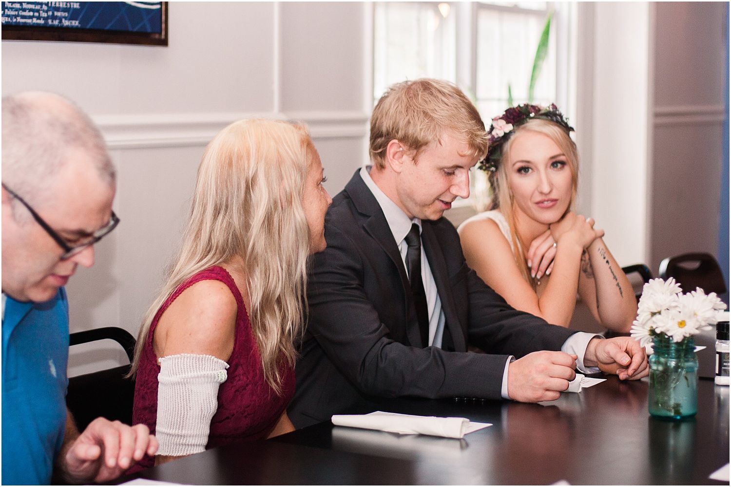 People seated at a formal event table engage in conversation during a gathering.