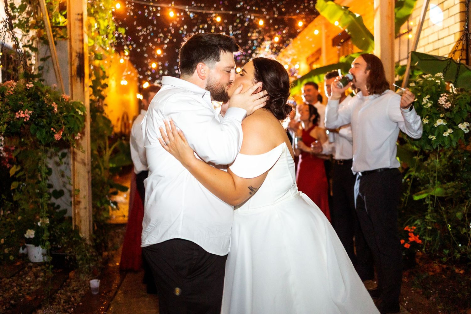 Wedding celebration at night with string lights creating a magical atmosphere.