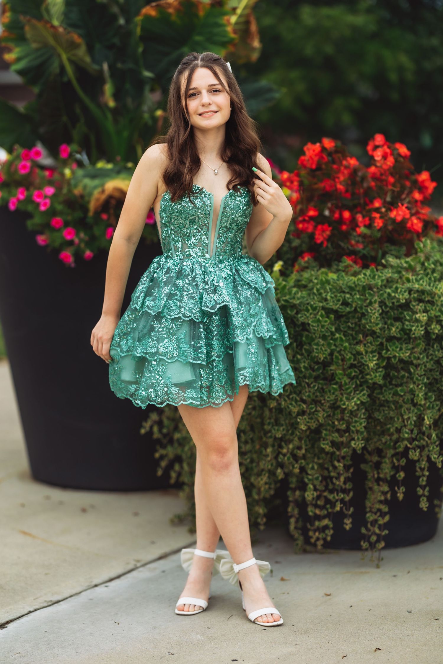 Fashion portraits showcasing a green sequined dress against floral garden backdrop.