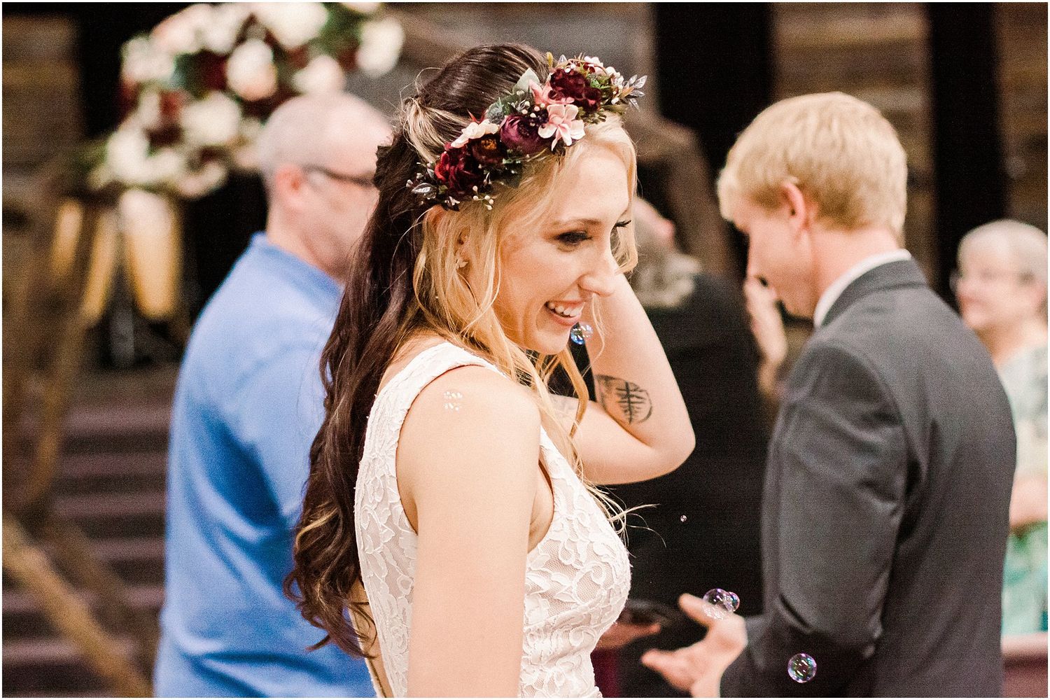 A celebratory wedding scene with a floral crown and white dress against wooden architecture.