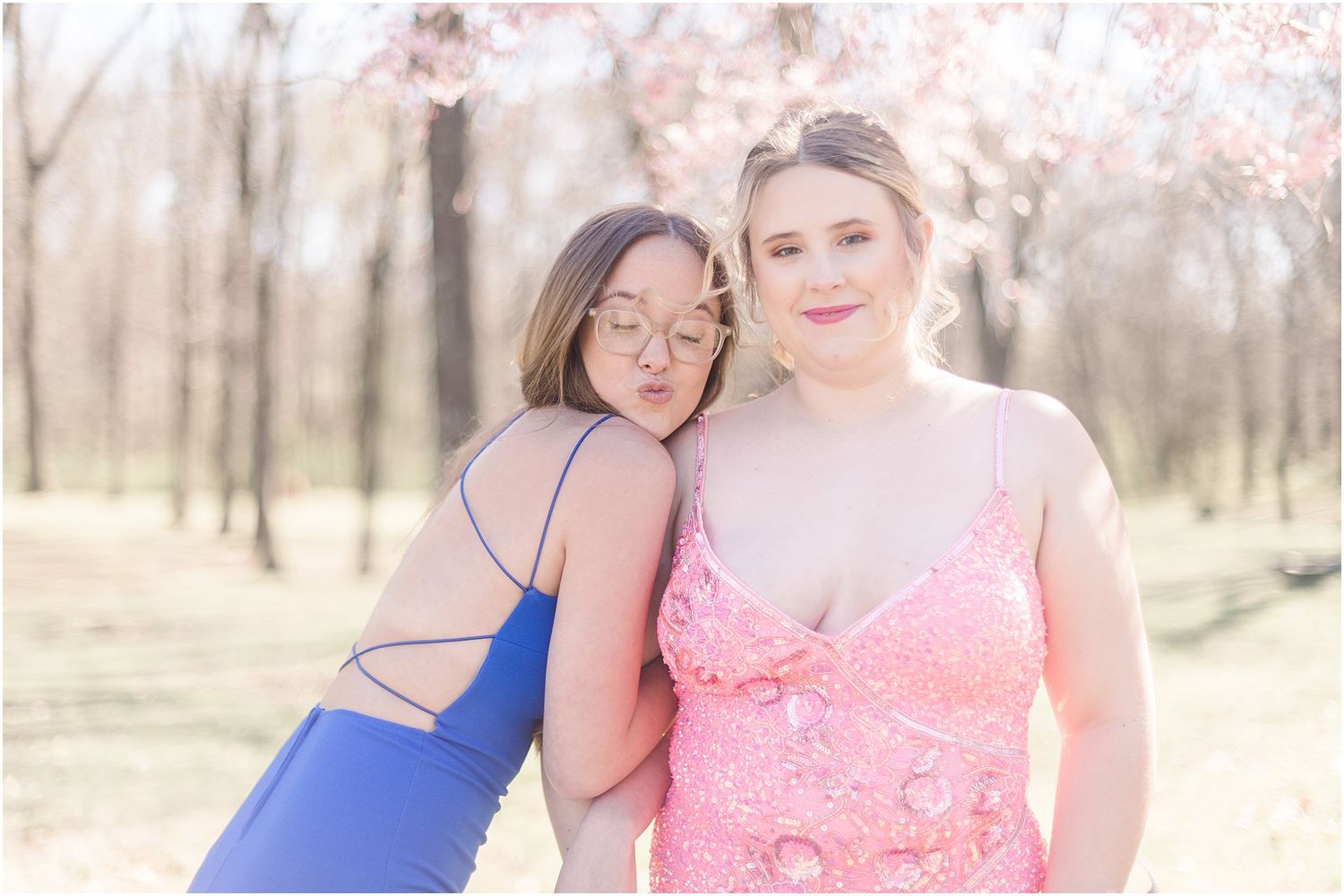 Friends in pink and blue formal dresses pose together during spring photo session.