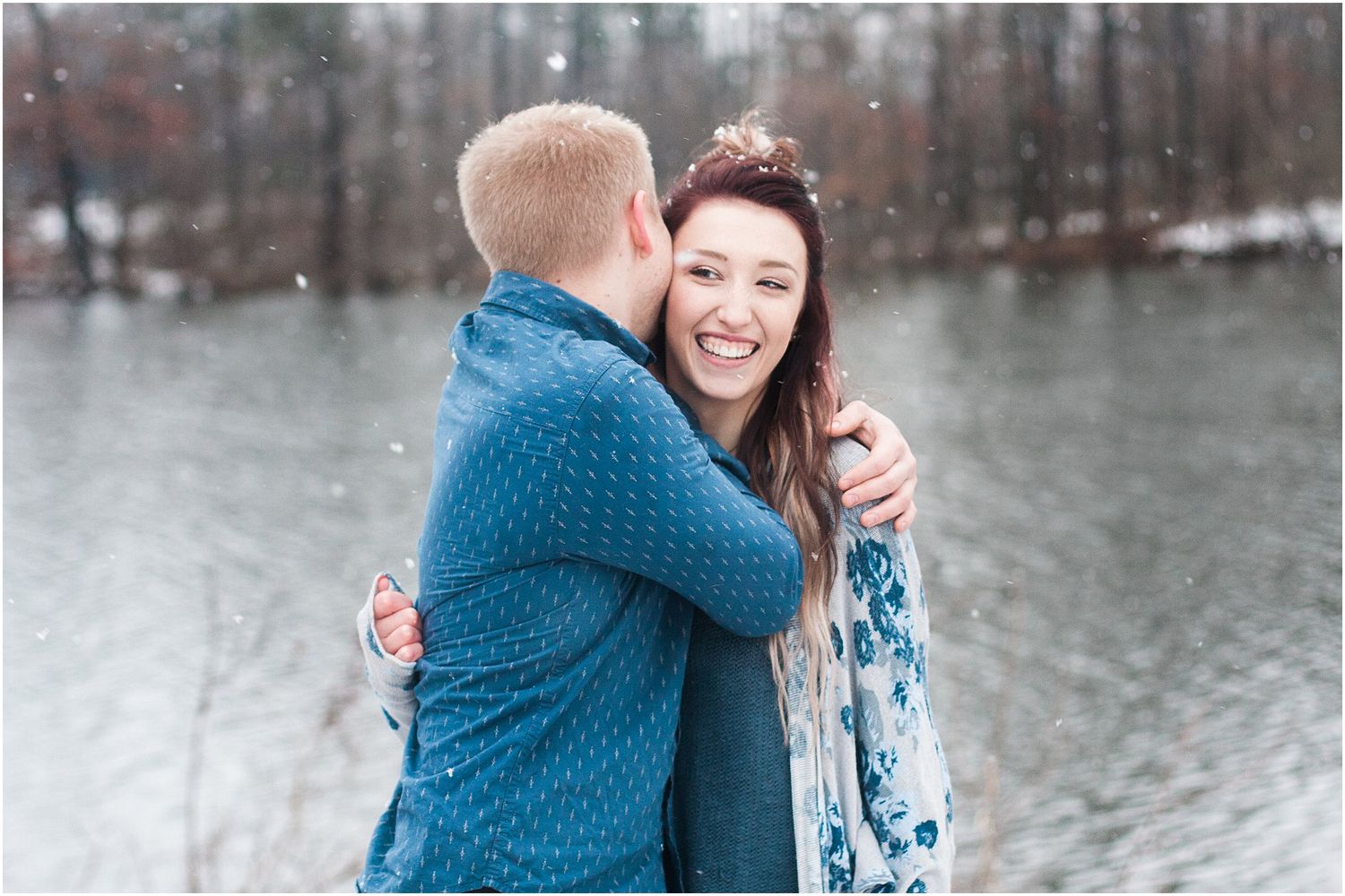 A sweet embrace captured during a winter couples photoshoot with snow falling in the background.