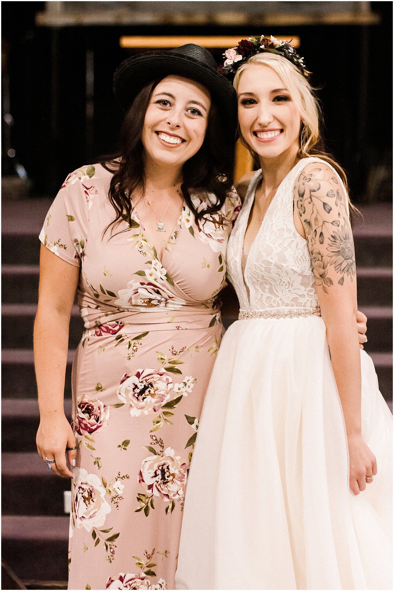 Wedding celebration featuring floral dress and white bridal gown on wooden steps.
