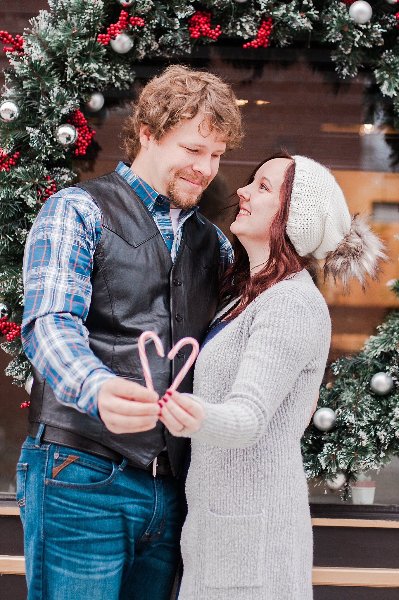 Couple holds up 2 candycanes to form the shape of a heart