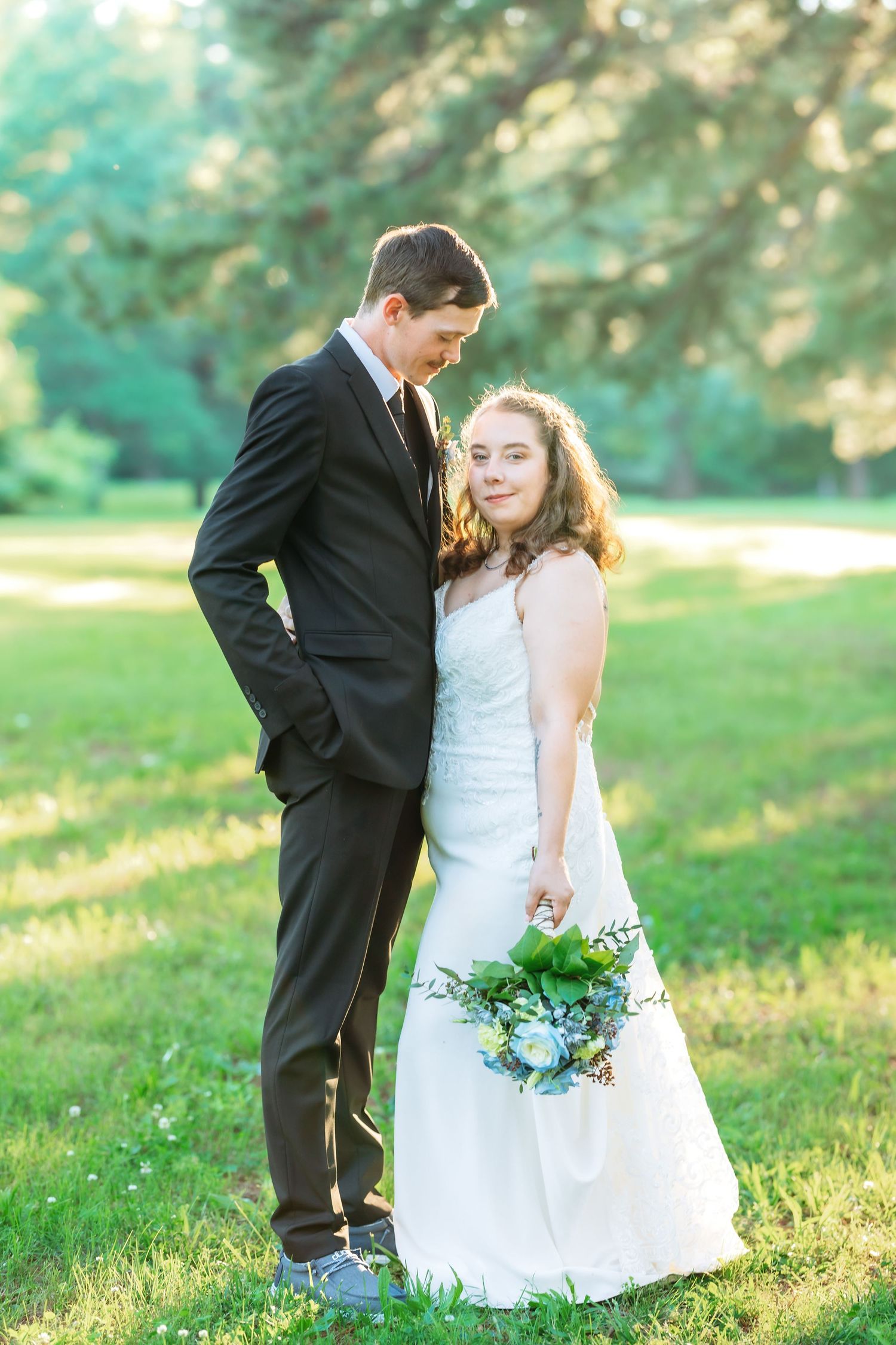 Romantic outdoor wedding photo session in golden sunlit grass.
