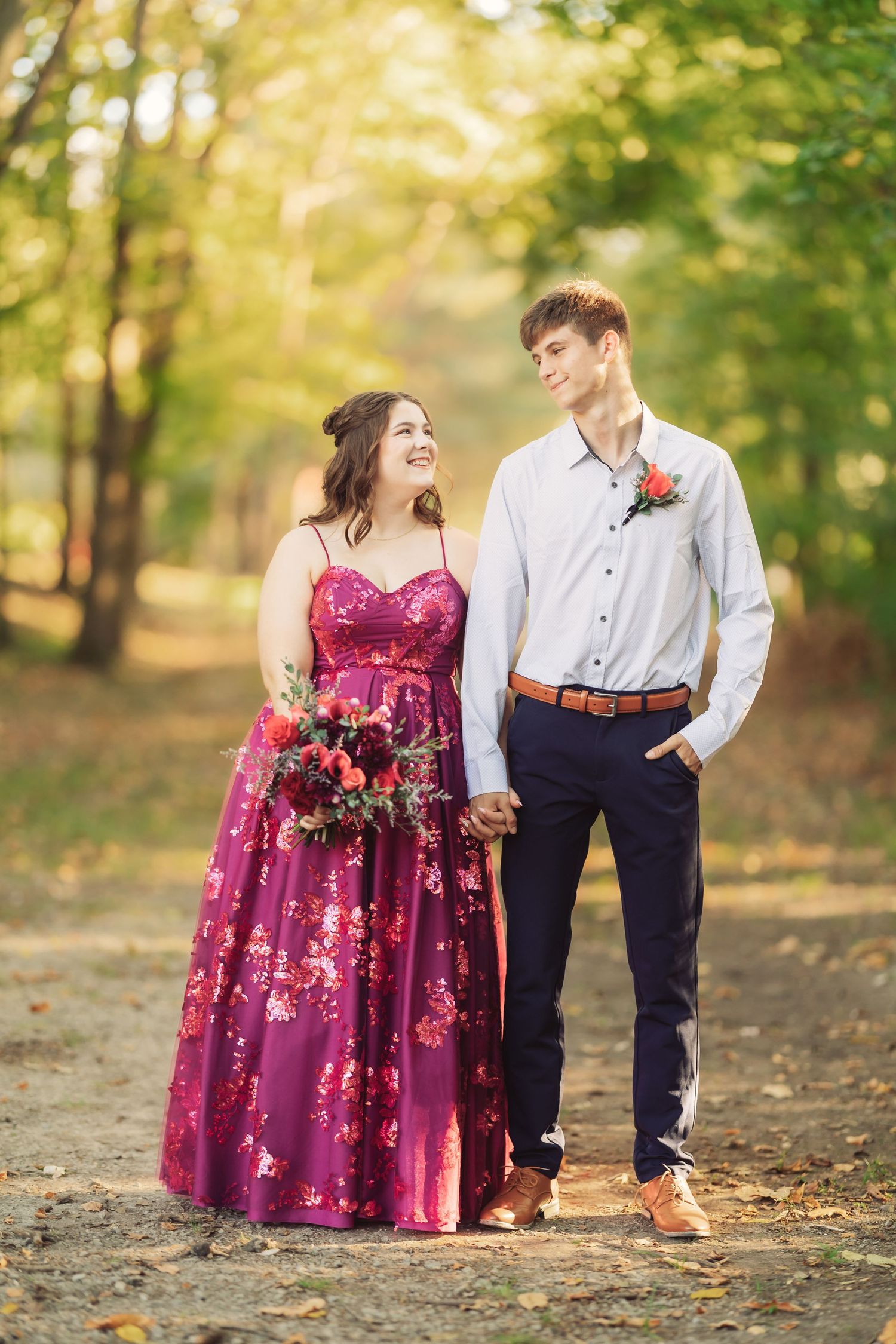 Romantic outdoor portraits of a couple in formal wear with burgundy floral gown.