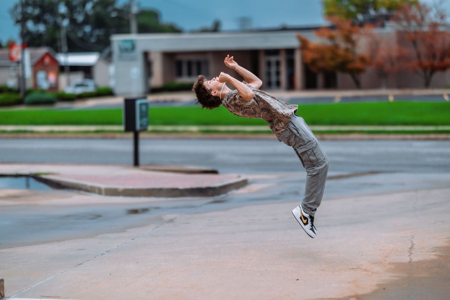 A skateboarder performs a trick sequence at a concrete skate park during daytime.