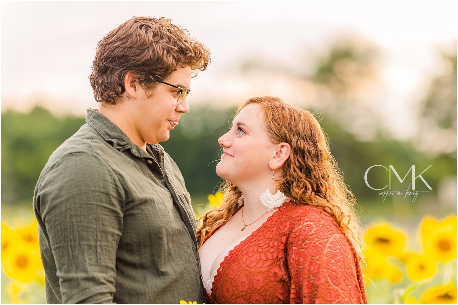 A loving couple sharing a romantic moment in a field of sunflowers at sunset.