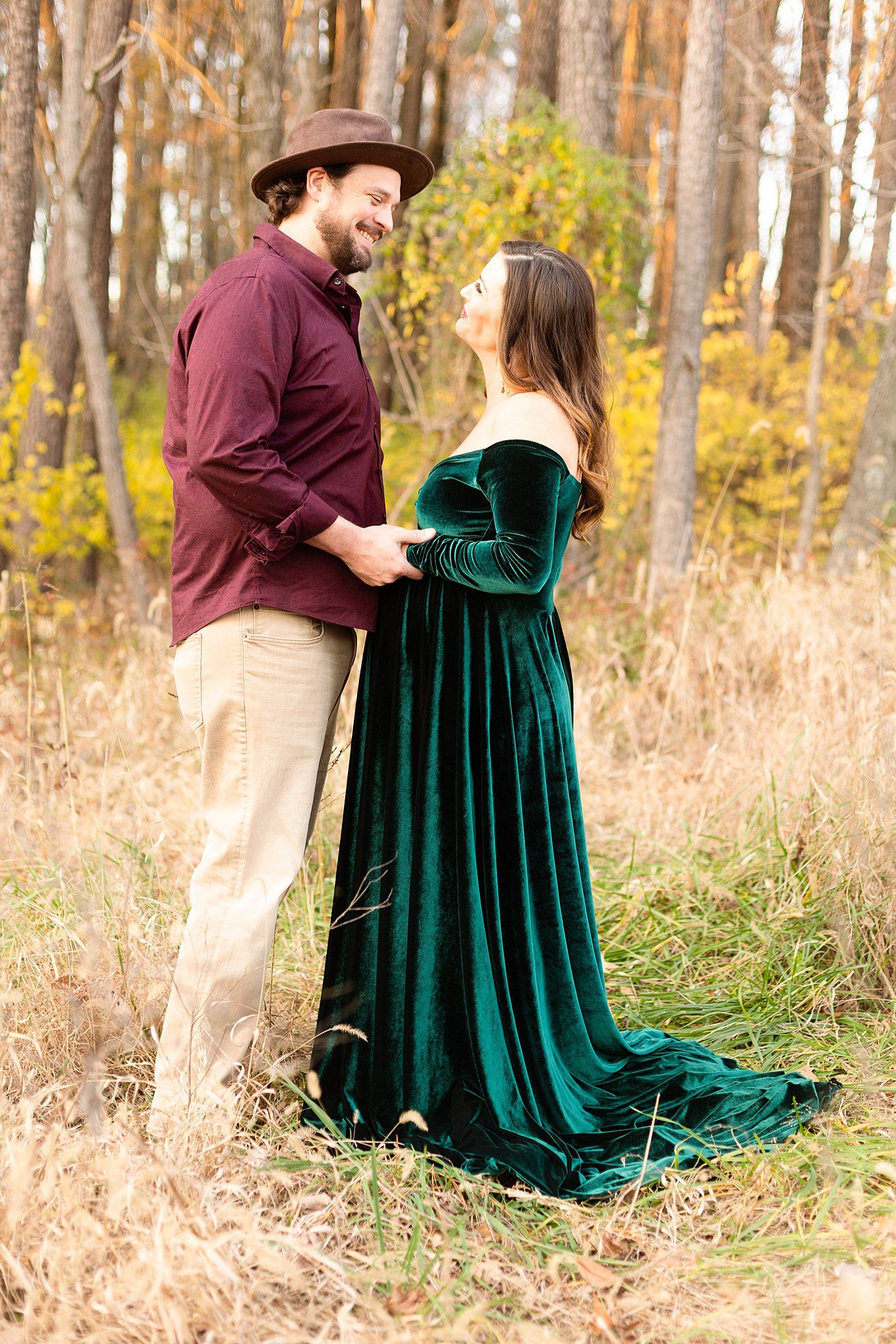 Joyful couple sharing intimate moment in autumn field wearing coordinated formal attire.