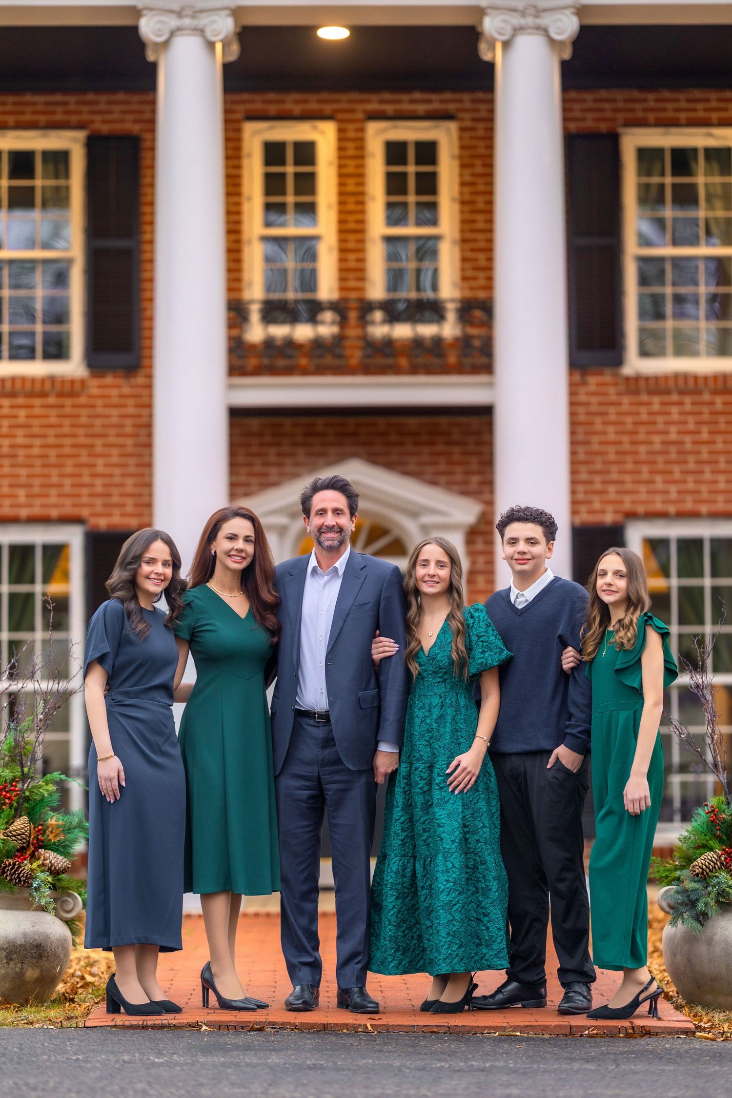 Formal group portrait in front of brick building with white columns.