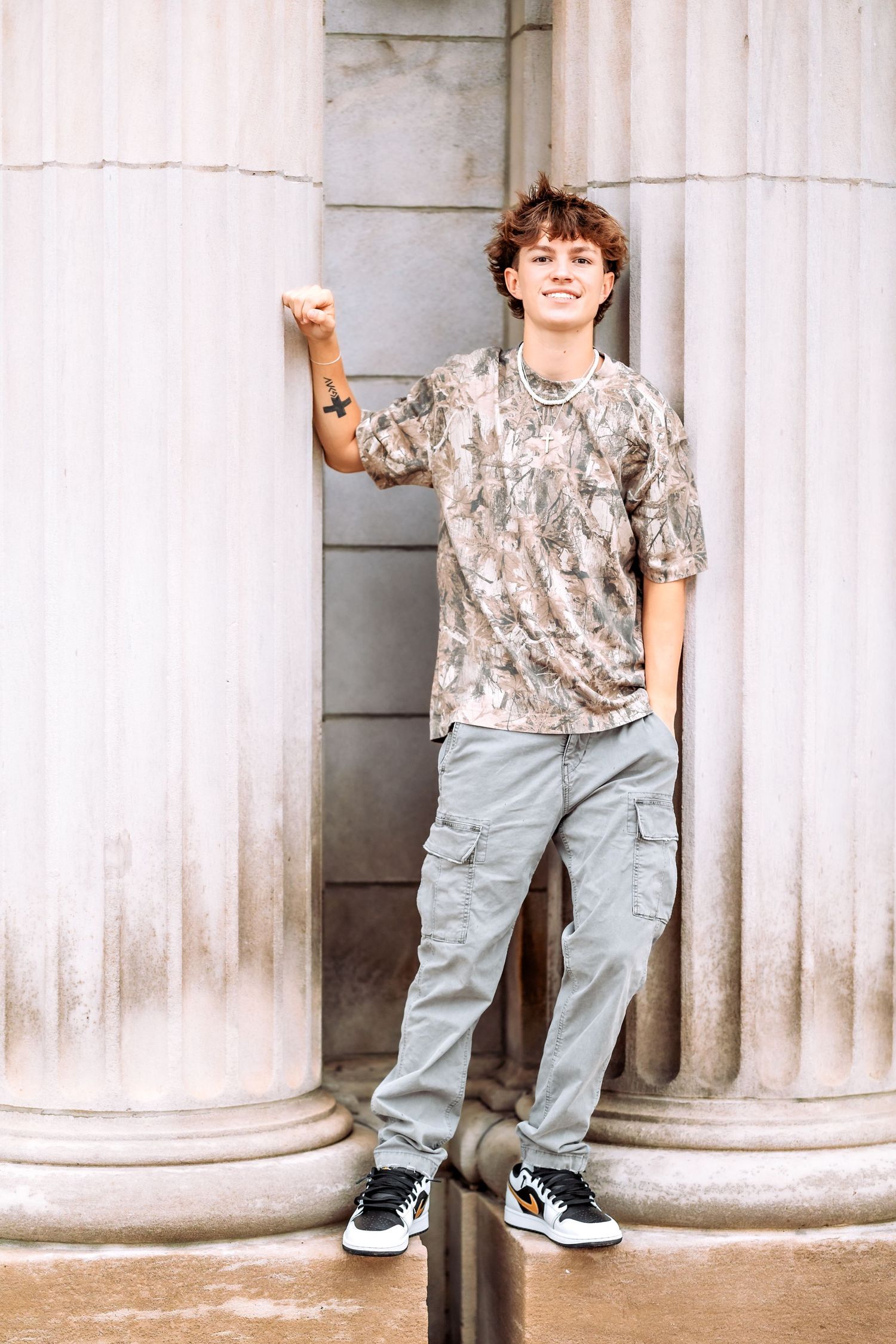 Young child in casual attire poses playfully against white stone columns in a four-panel photo series.