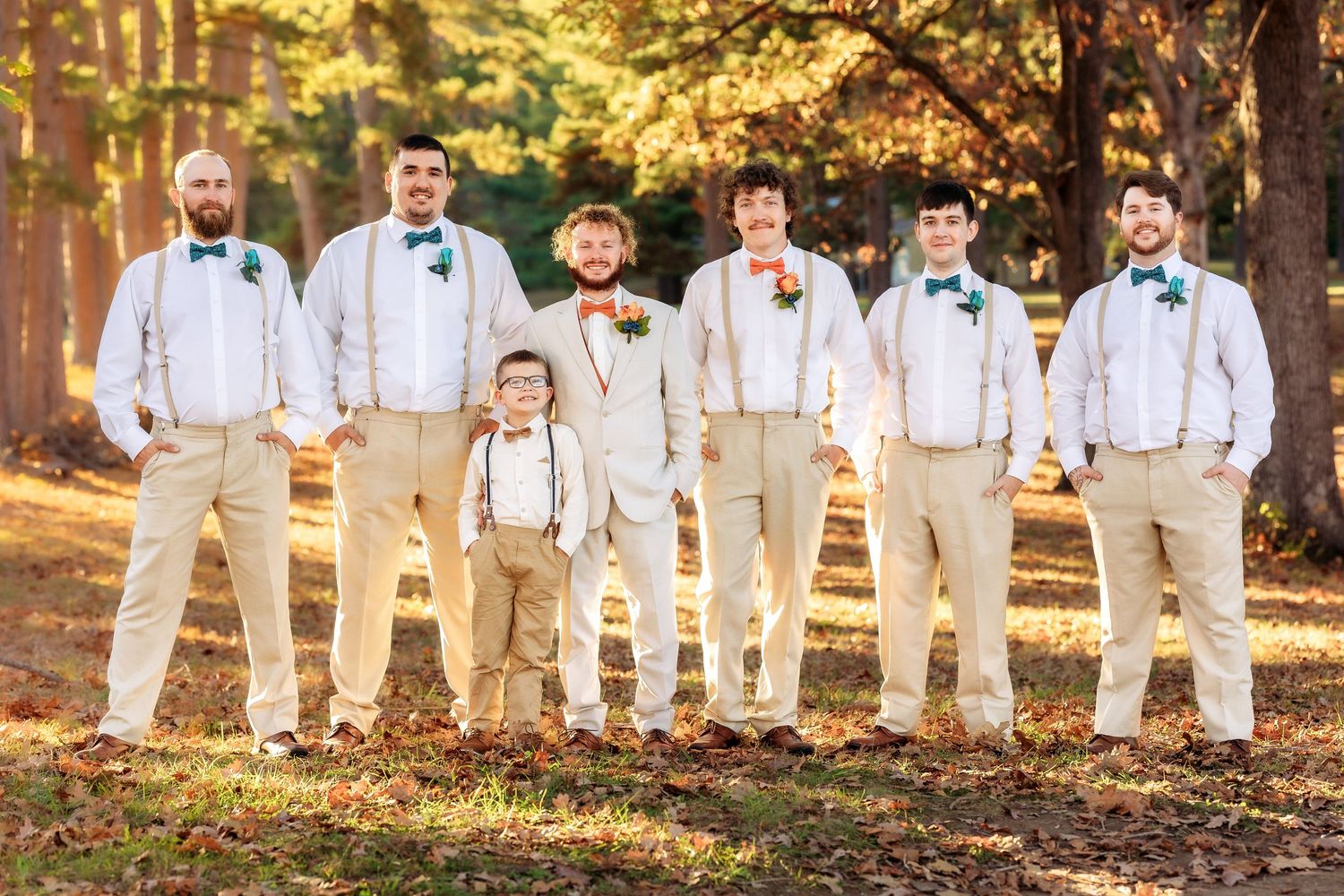 Groomsmen in white and khaki attire pose in casual outdoor setting.