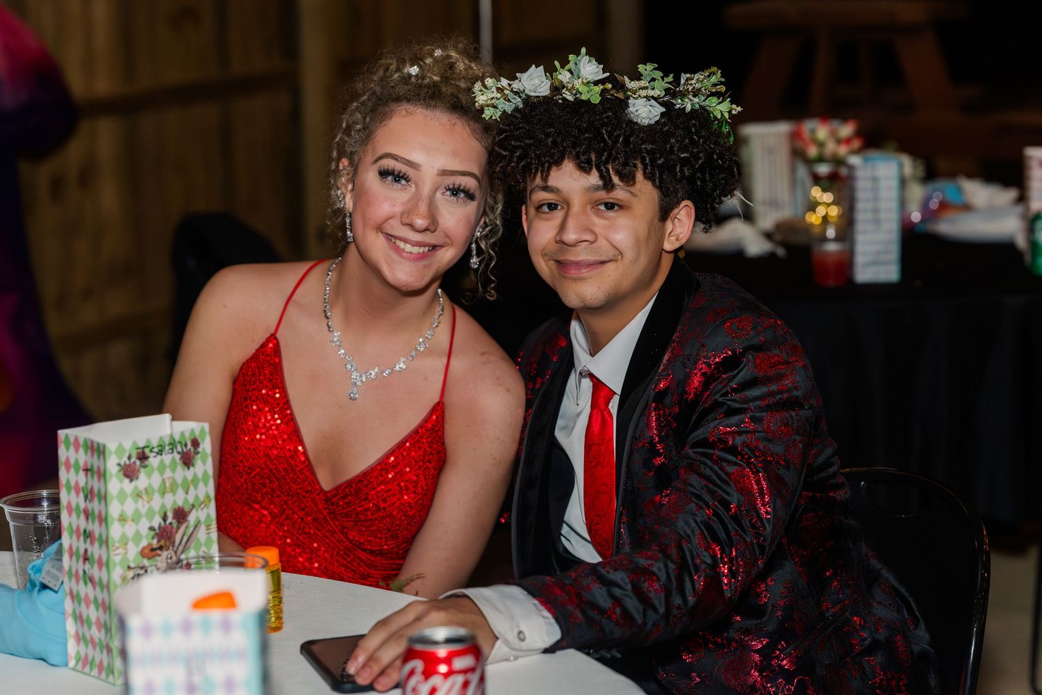 Couples enjoying a formal dinner event with wrapped presents on the tables.