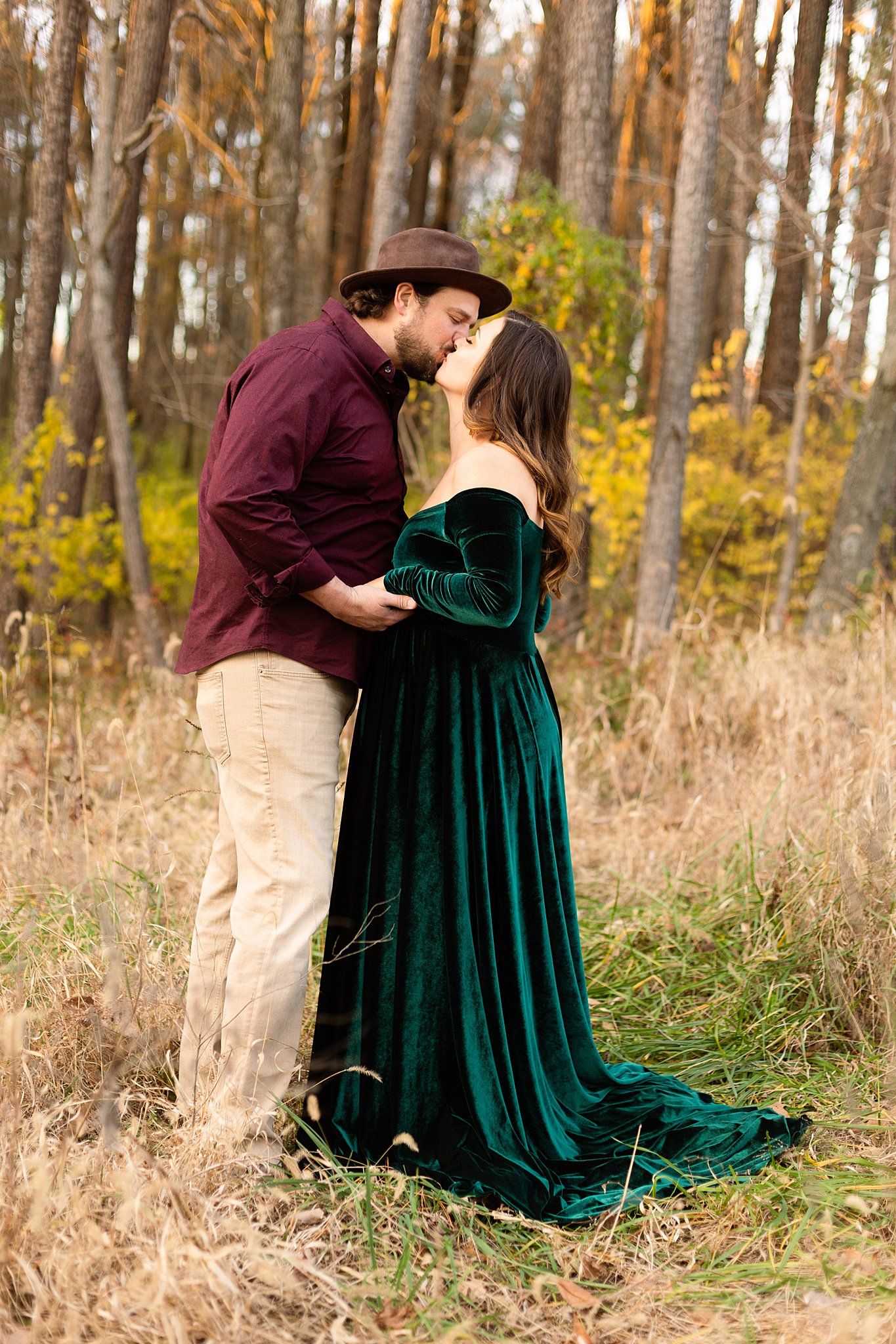 Intimate couple's portrait in rustic setting with burgundy shirt and emerald velvet gown.