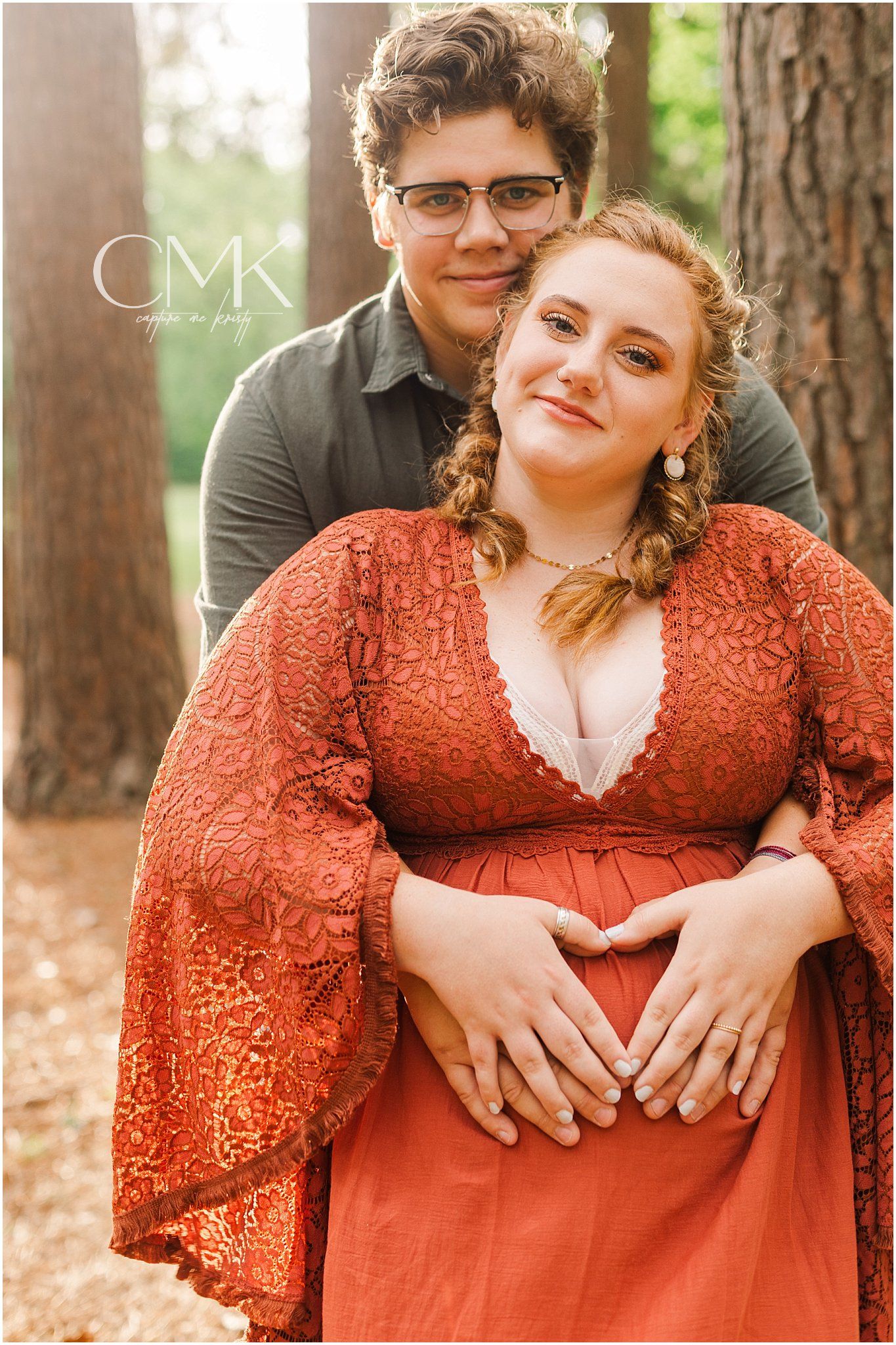 A tender moment captured between a couple in a wooded setting with autumn tones.