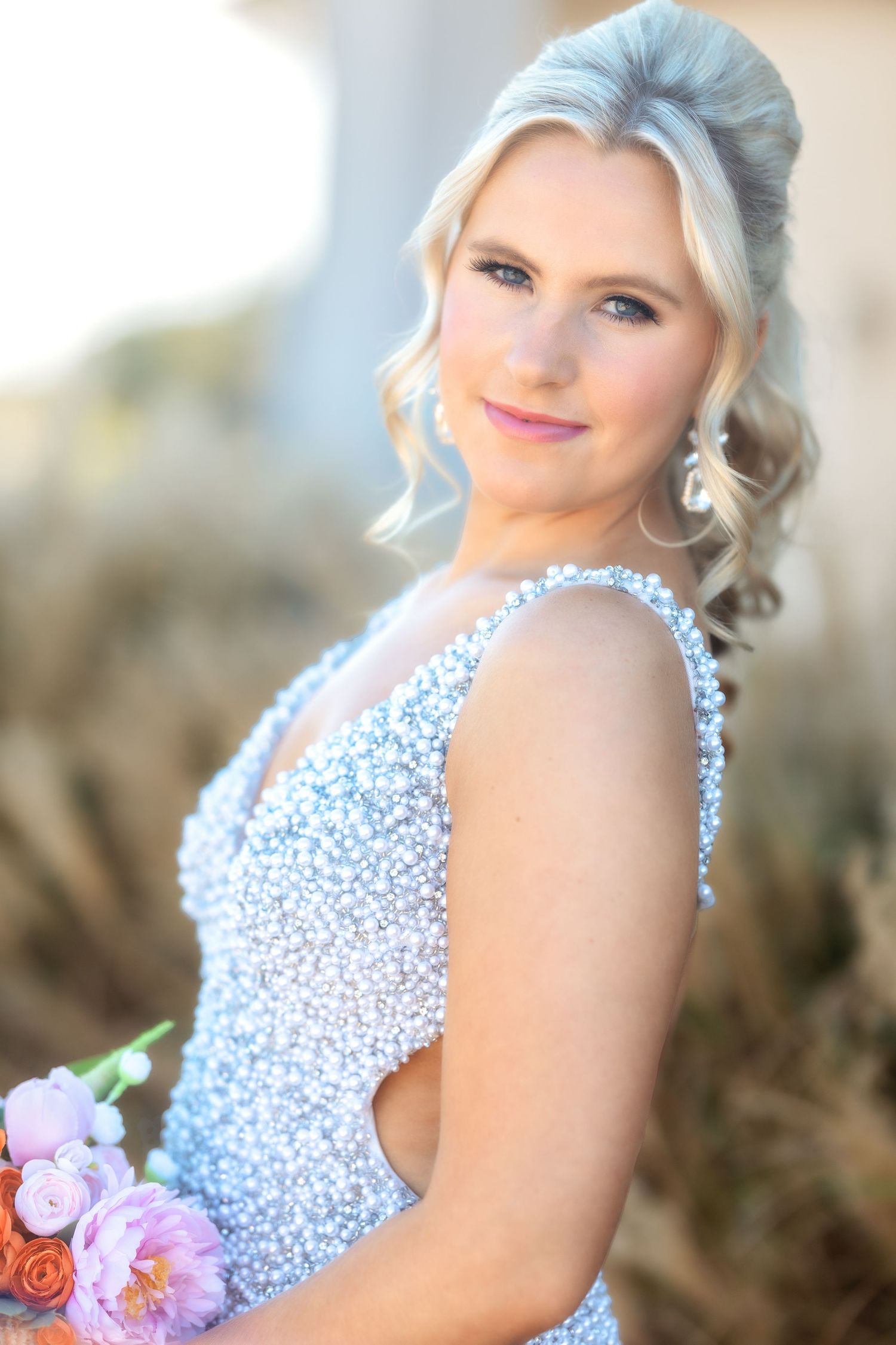 Beaded light blue formal dress with floral accents captured in soft lighting.