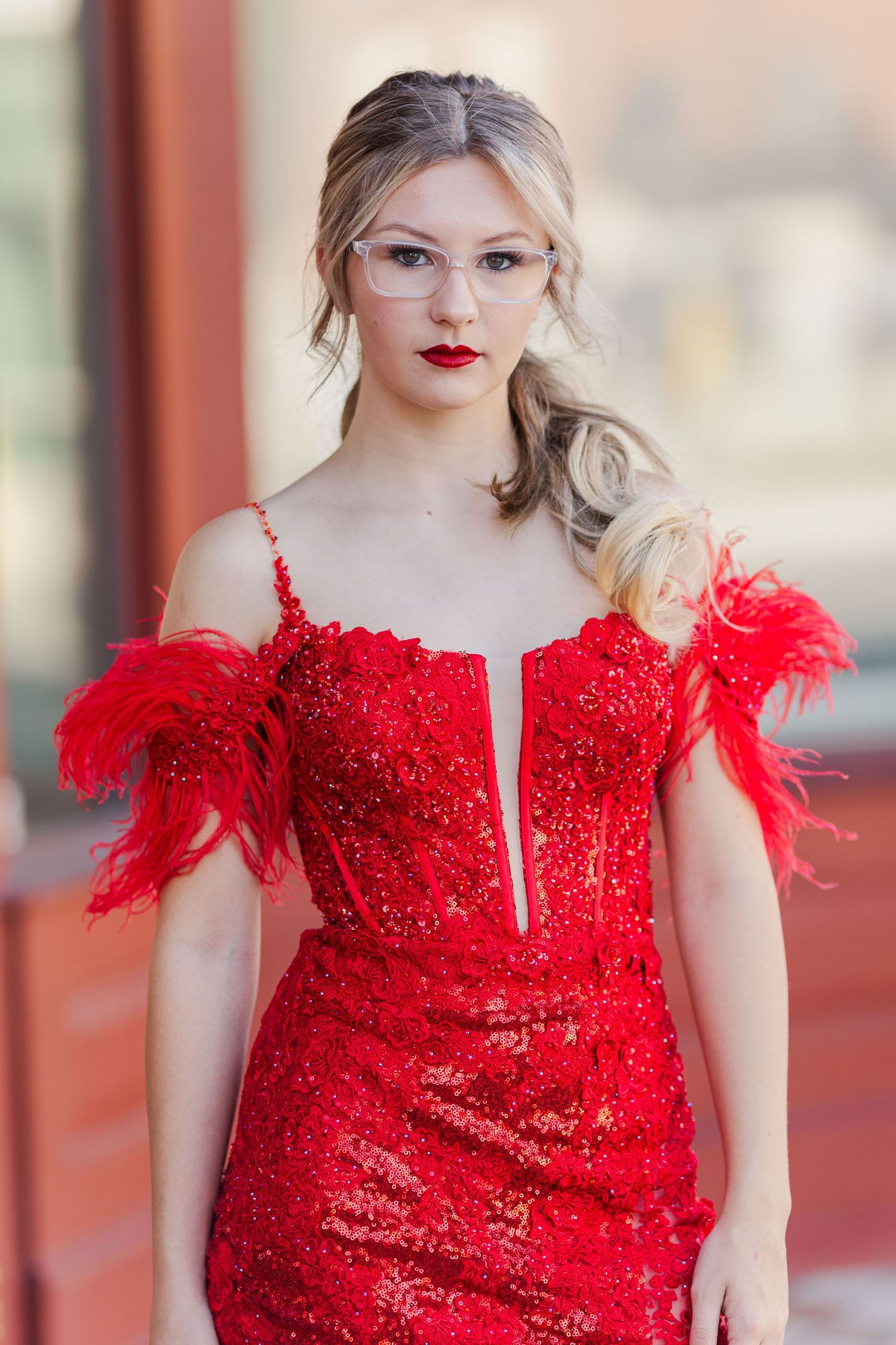 A stunning red sequined dress with feather details and a plunging neckline.