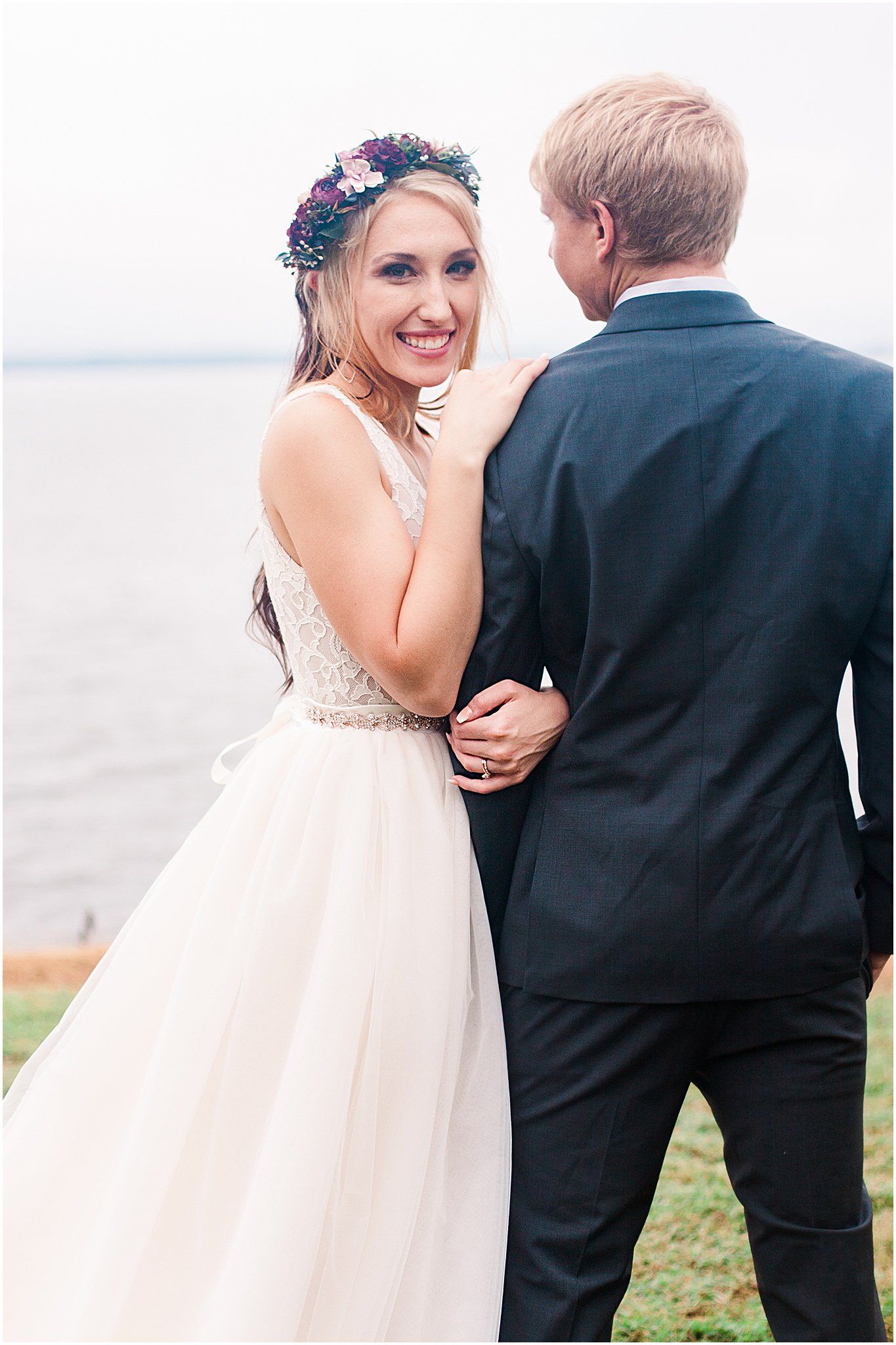 Sweet candid moment between newlyweds during their lakeside wedding photoshoot.